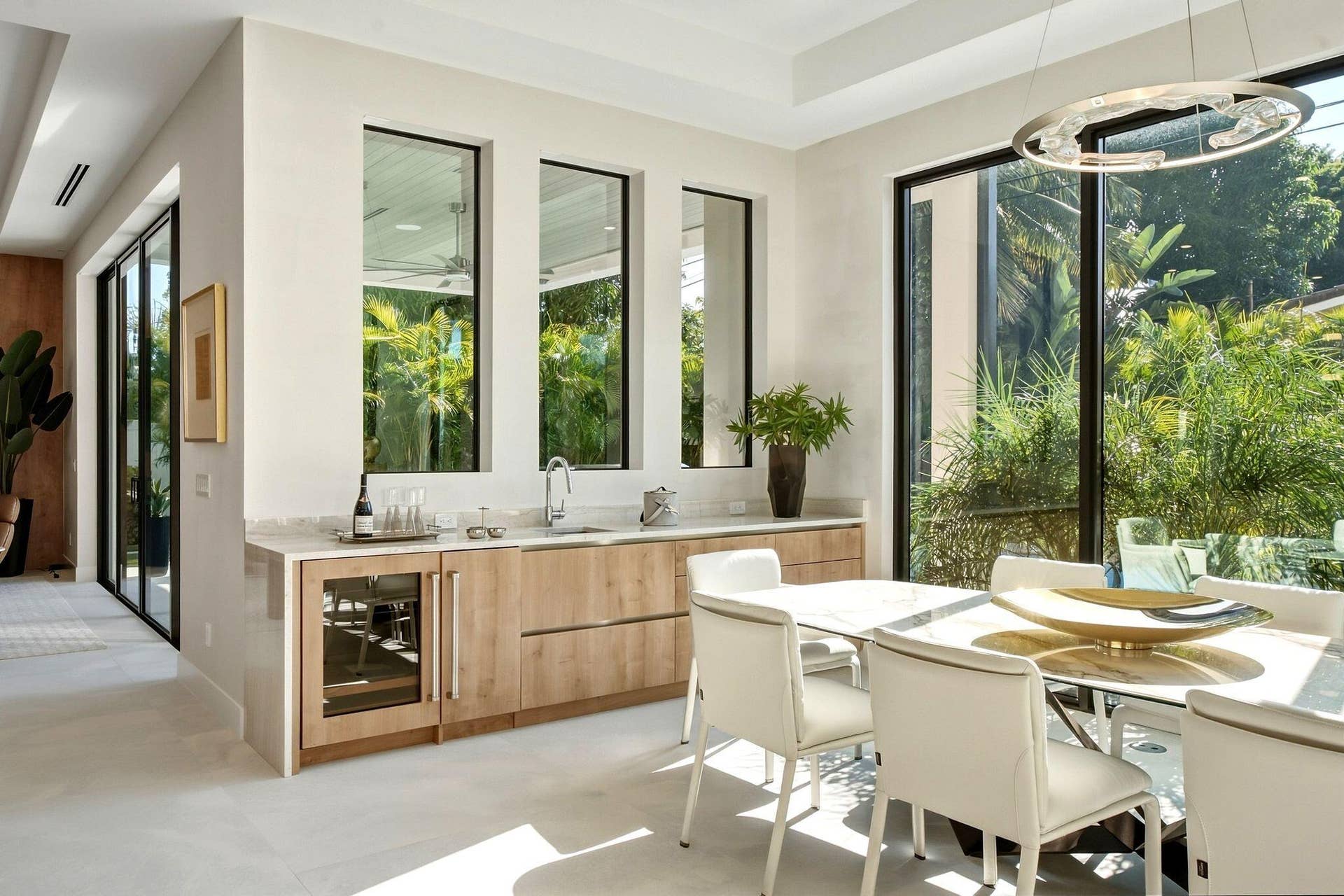 Built-in wet bar with wood-finish cabinetry, under-counter beverage cooler, and integrated sink