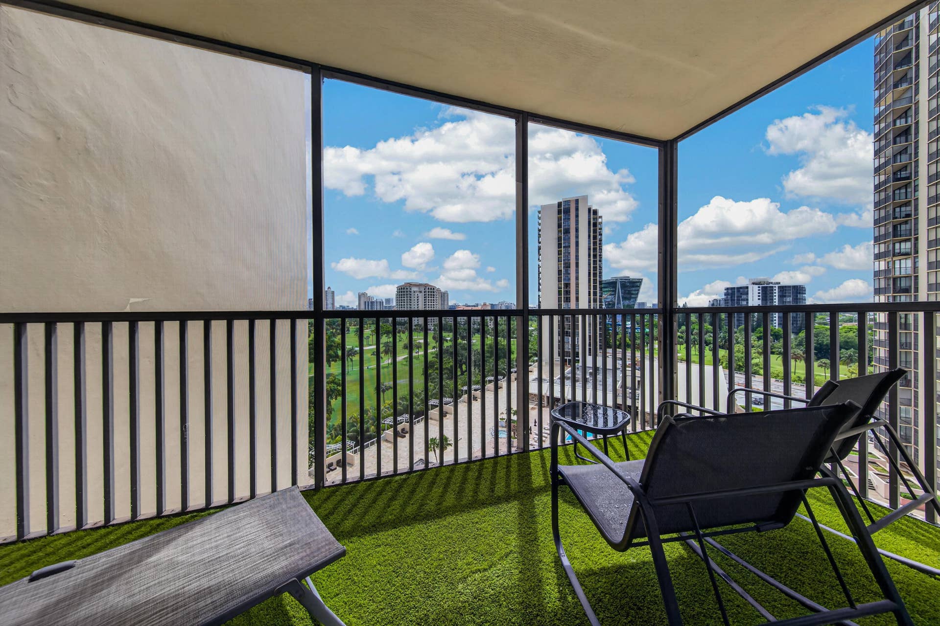 20379 W COUNTRY CLUB Drive, #1139, Aventura, FL 33180 Balcony with black metal railings, artificial turf flooring, and a cityscape backdrop