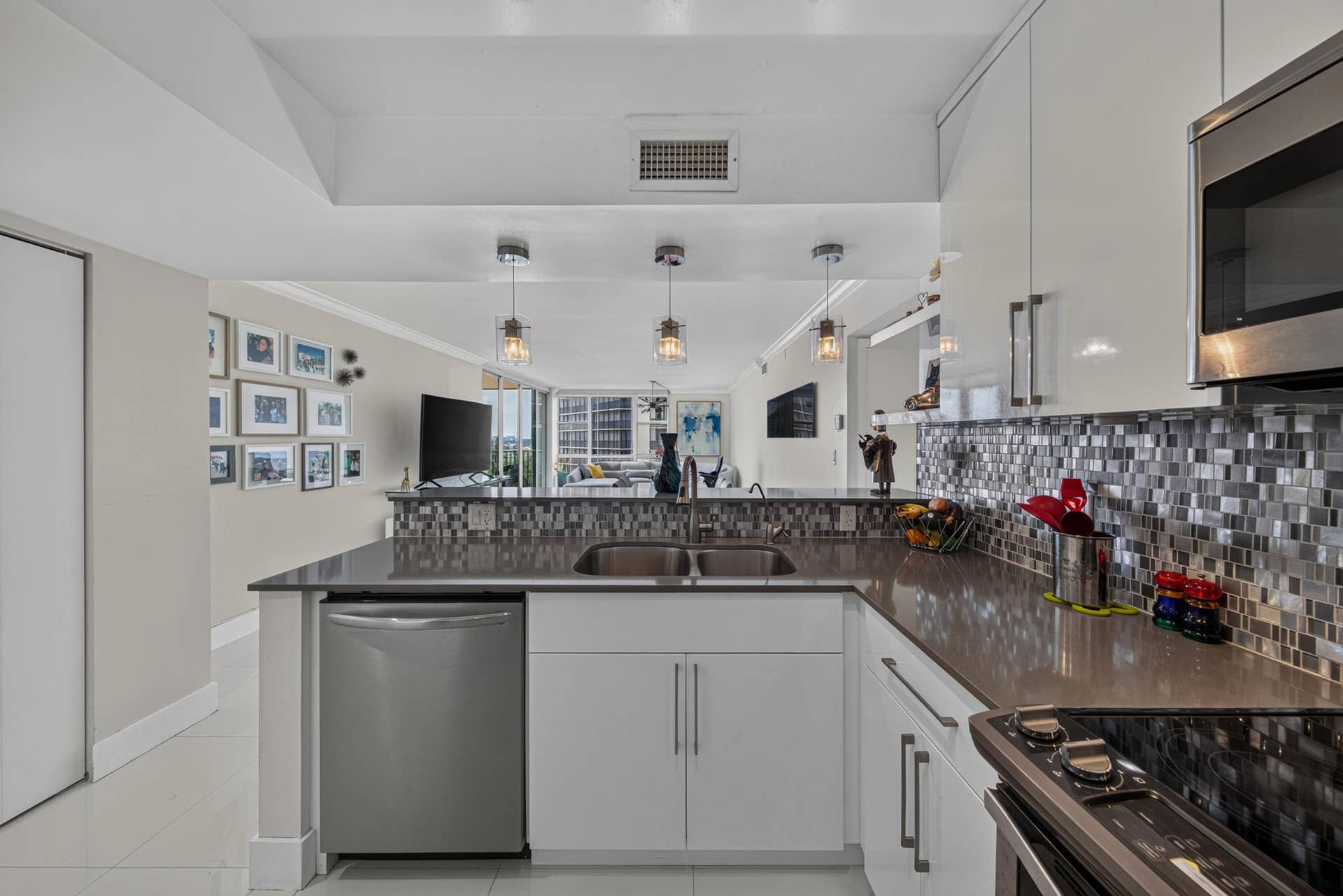 20379 W COUNTRY CLUB Drive, #1139, Aventura, FL 33180 Modern kitchen featuring white cabinetry, stainless steel appliances, a mosaic tile backsplash, and dark stone countertops