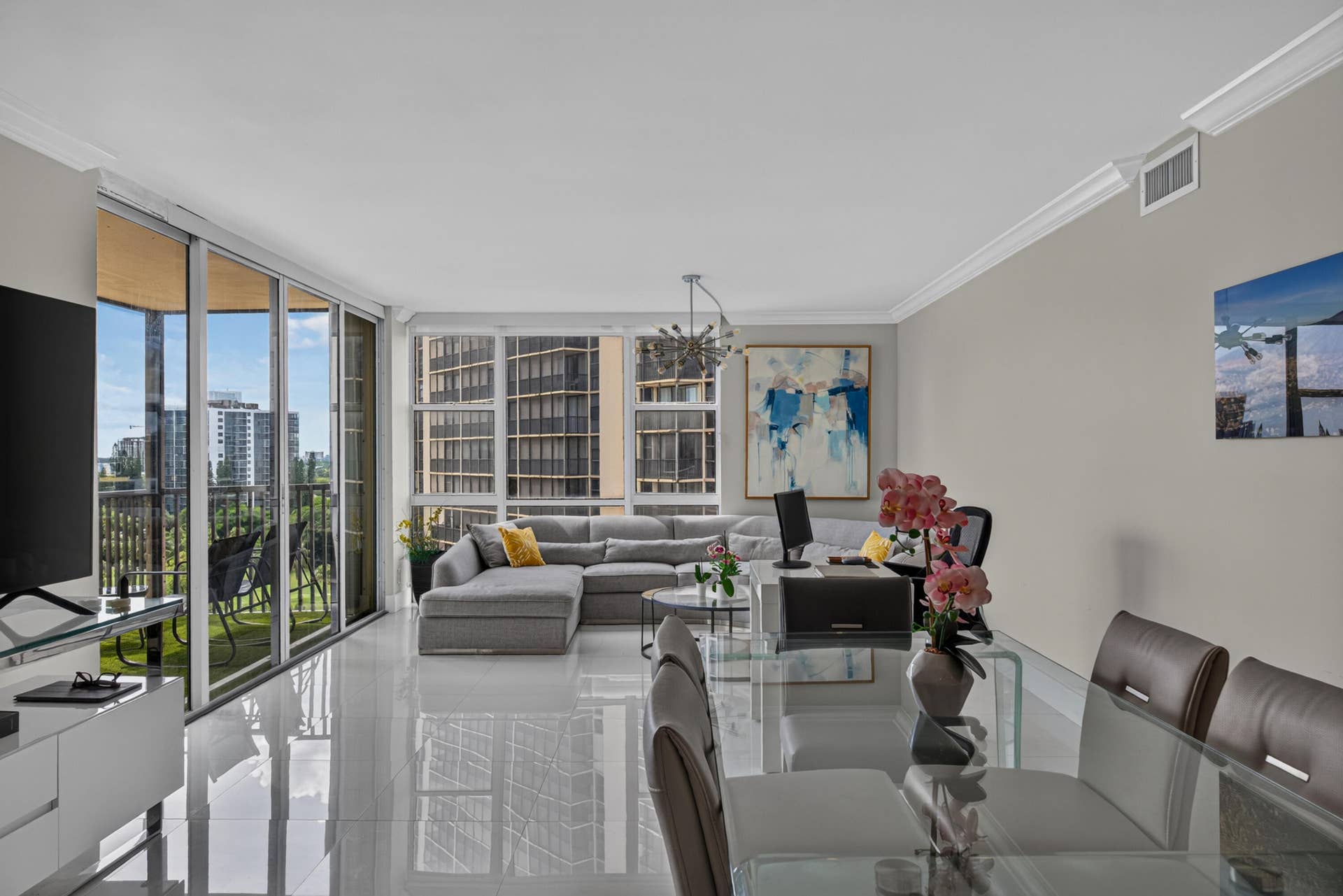 20379 W COUNTRY CLUB Drive, #1139, Aventura, FL 33180 Contemporary open-concept living area featuring floor-to-ceiling glass sliding doors, polished light-finish flooring throughout, and abundant natural light