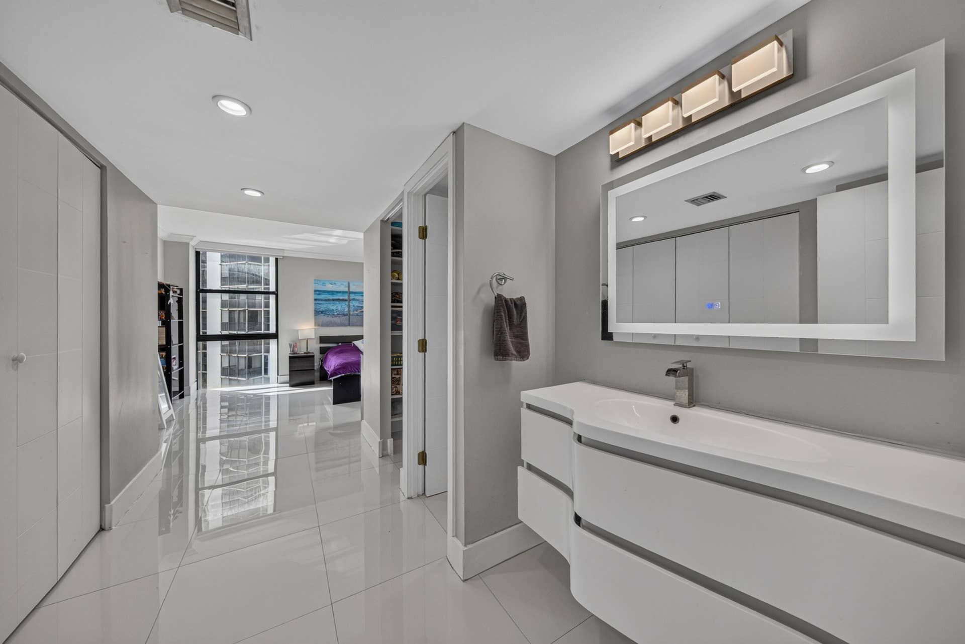 20379 W COUNTRY CLUB Drive, #1139, Aventura, FL 33180 Modern vanity with integrated sink, rectangular illuminated mirror, and wall-mounted light fixture