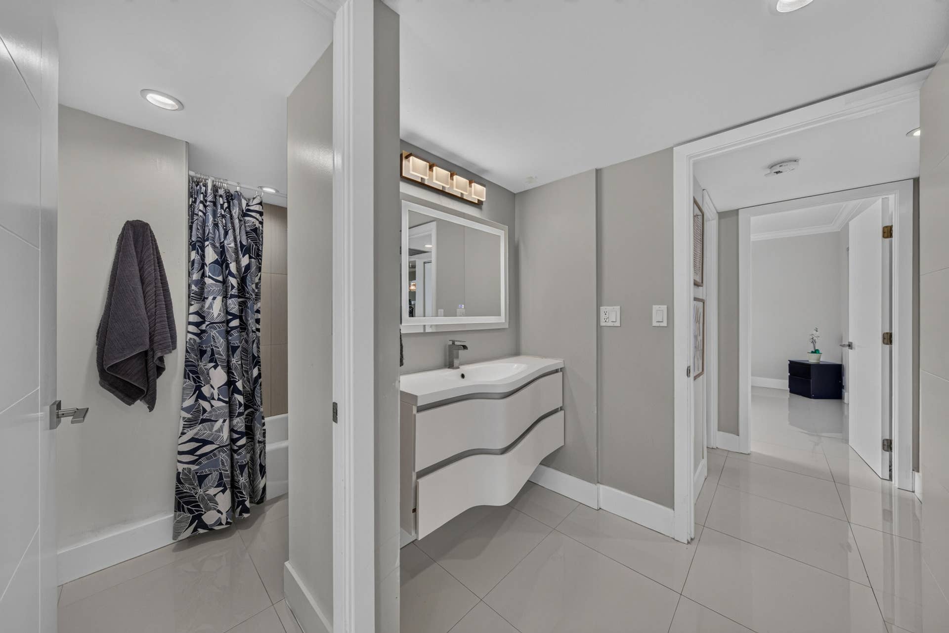 20379 W COUNTRY CLUB Drive, #1139, Aventura, FL 33180 Contemporary bathroom featuring a modern floating vanity with an integrated sink, rectangular mirror, and an overhead vanity light fixture