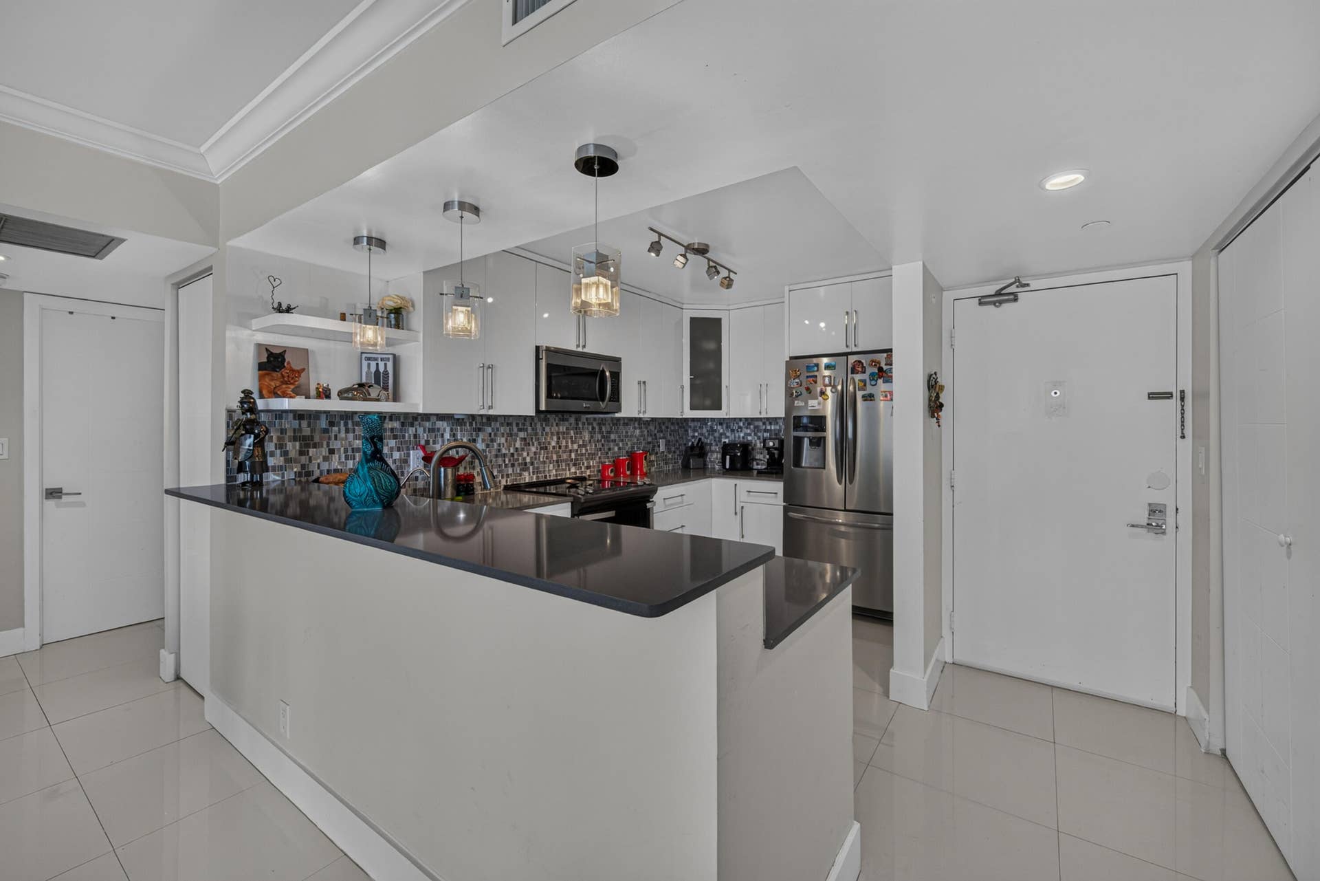 20379 W COUNTRY CLUB Drive, #1139, Aventura, FL 33180 Kitchen featuring a breakfast bar, dark countertops, a mosaic tile backsplash, white cabinetry, and stainless steel appliances