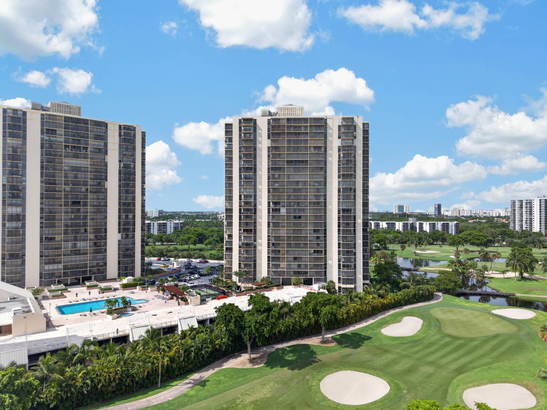 20379 W COUNTRY CLUB Drive, #1139, Aventura, FL 33180 High-rise building with extensive window lines, surrounded by a golf course, mature landscaping, and an outdoor swimming pool