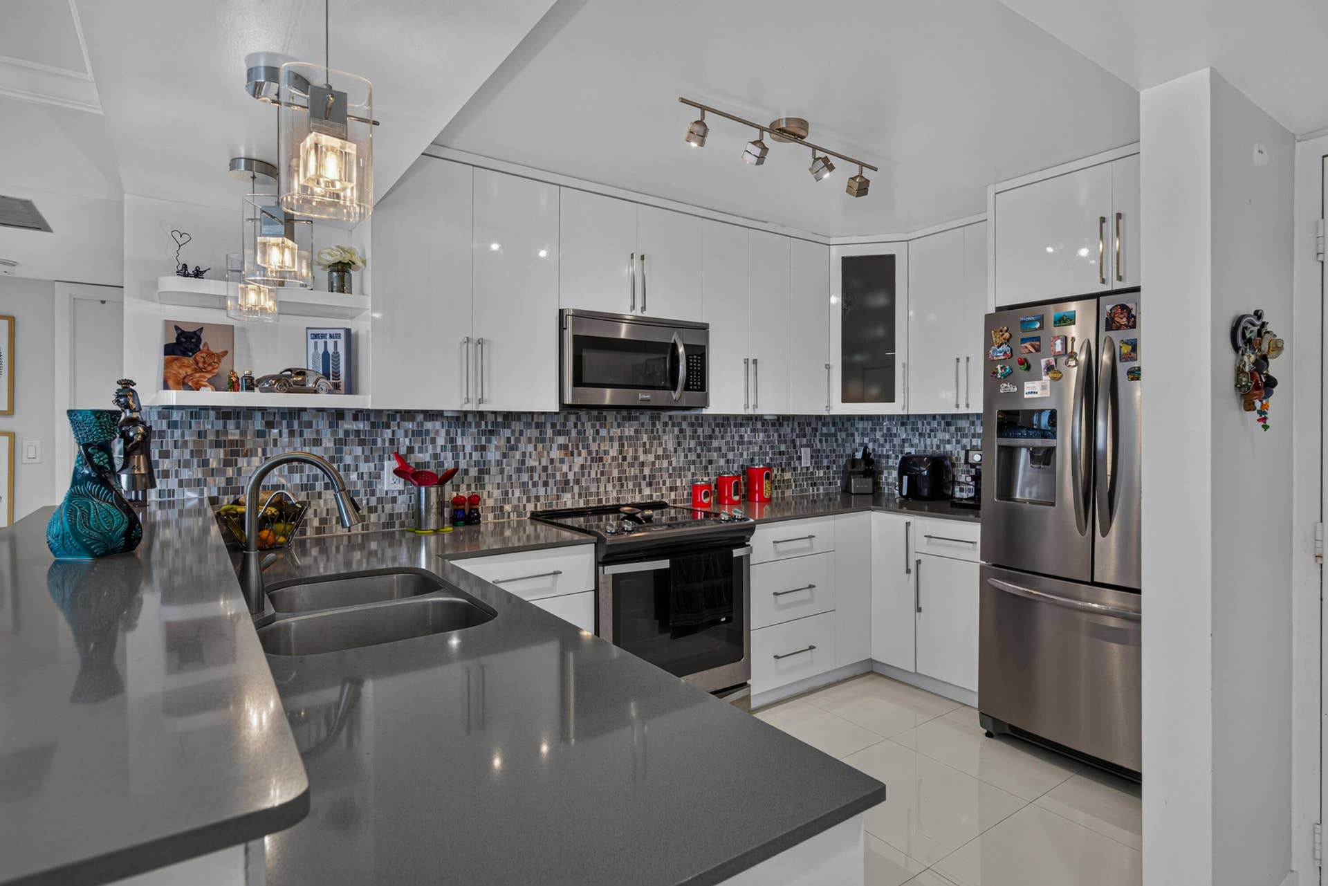 20379 W COUNTRY CLUB Drive, #1139, Aventura, FL 33180 Contemporary kitchen with sleek white cabinetry, stainless steel appliances, dark countertops, and a mosaic tile backsplash
