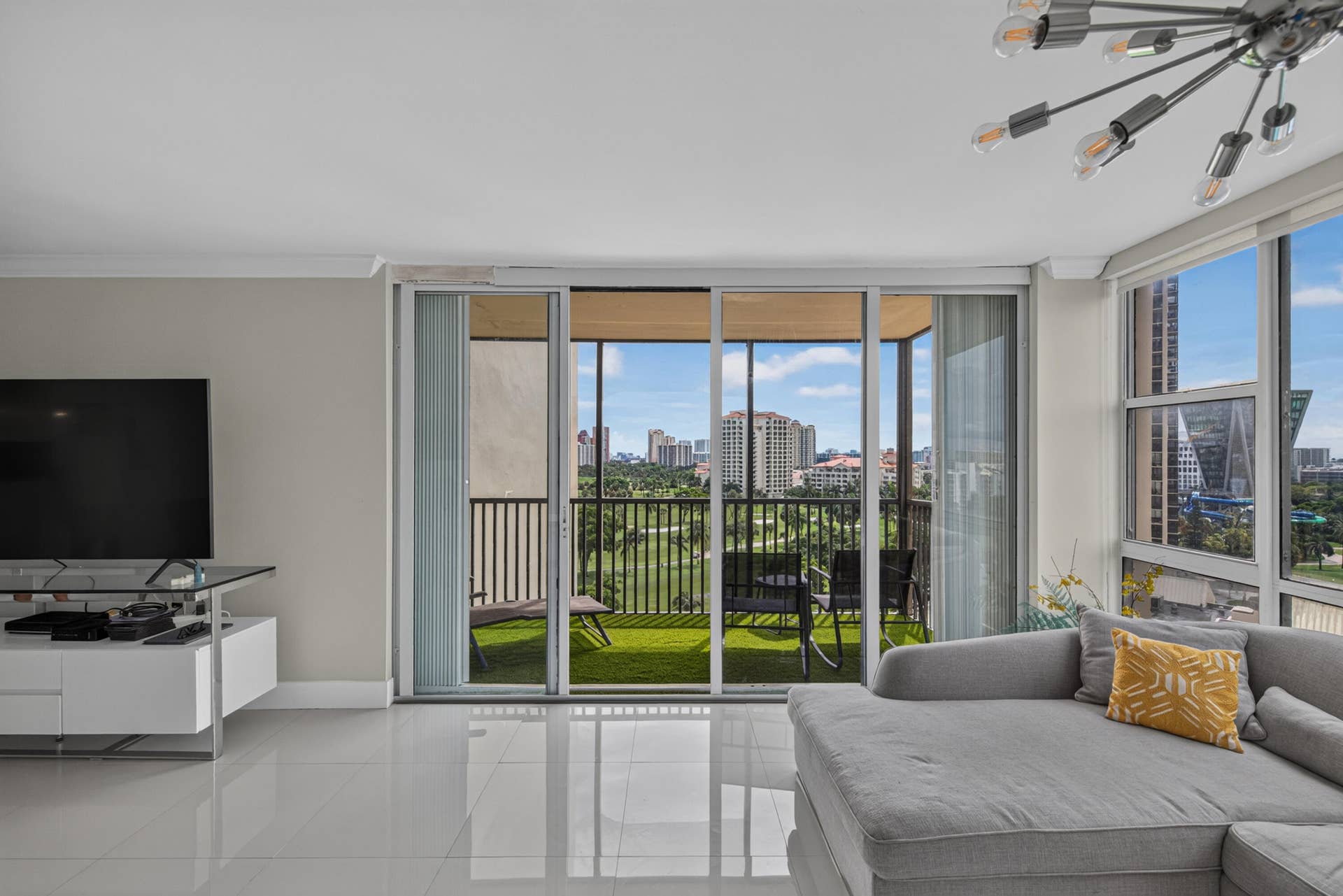 20379 W COUNTRY CLUB Drive, #1139, Aventura, FL 33180 Living area with large format tile flooring, crown molding, and a modern Sputnik-style light fixture