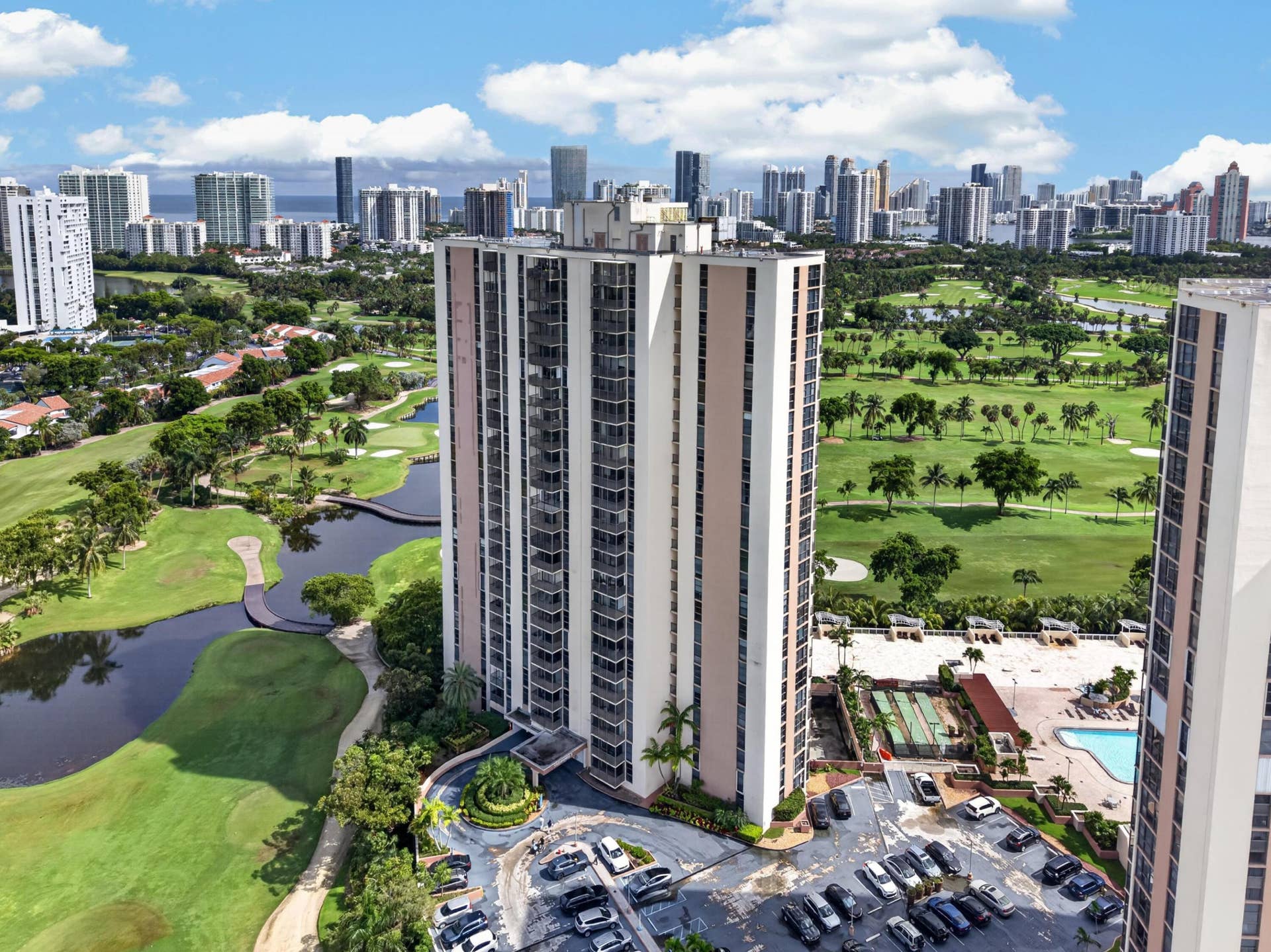 20379 W COUNTRY CLUB Drive, #1139, Aventura, FL 33180 High-rise residential building with multiple balconies, adjacent to a golf course and water features