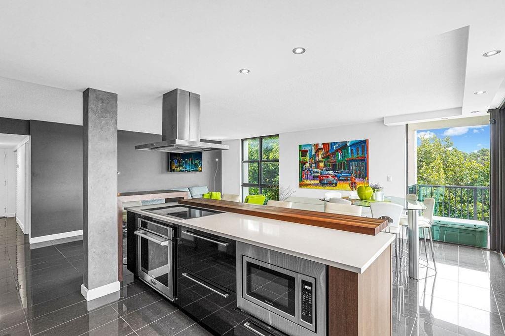 1350 River Reach Drive, #417, Fort Lauderdale, FL 33315 Open kitchen with white quartz & wood accent counter.