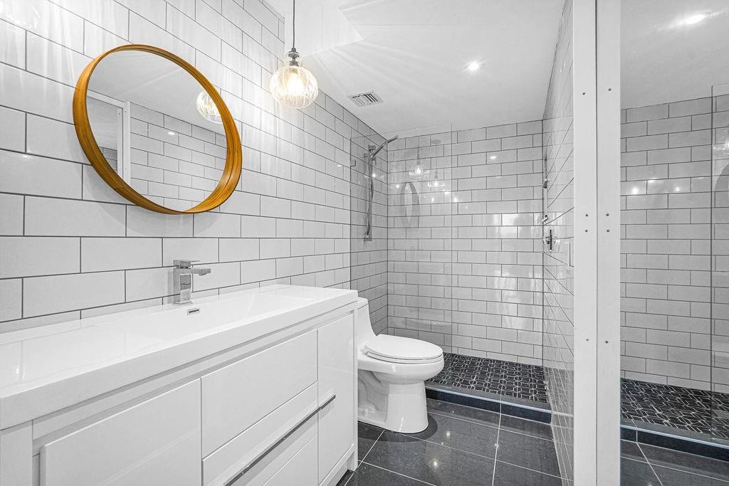 1350 River Reach Drive, #417, Fort Lauderdale, FL 33315 Chic white tile bathroom with step-in glass enclosed shower