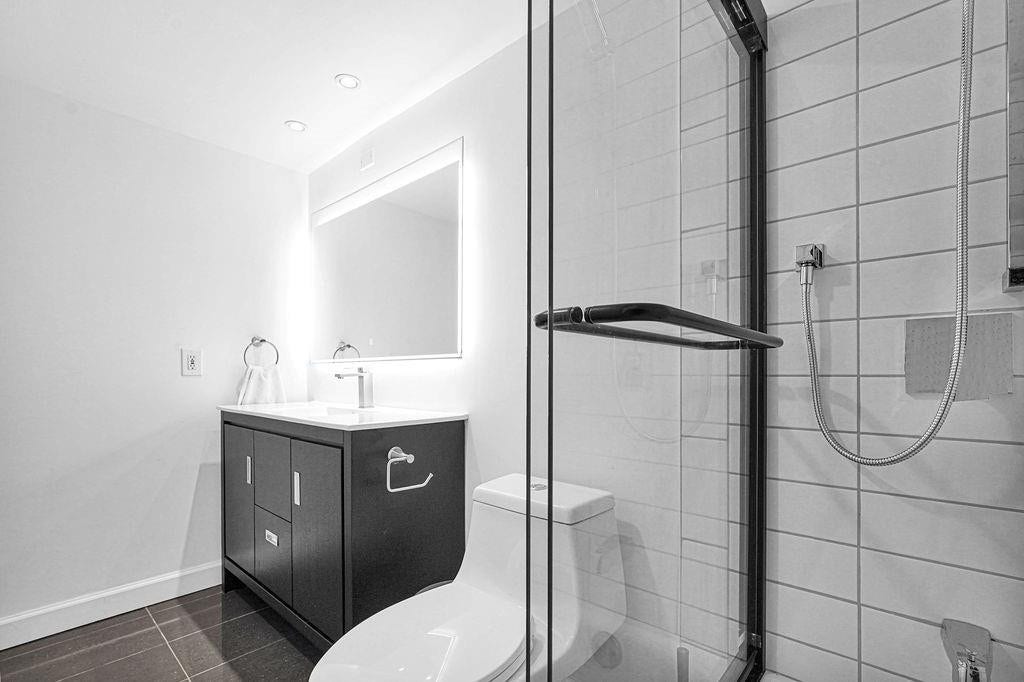 1350 River Reach Drive, #417, Fort Lauderdale, FL 33315 White tile, chic vanity & backlit mirror.