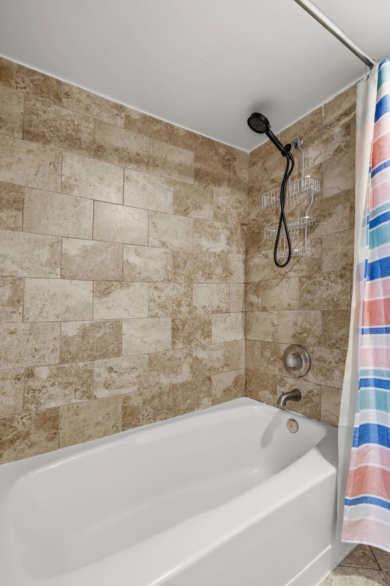 20101 Glenmoor Drive, West Palm Beach, West Palm Beach, FL 33409 Bathtub and shower combination featuring neutral-toned tile surround, white tub, and a matte black shower head fixture