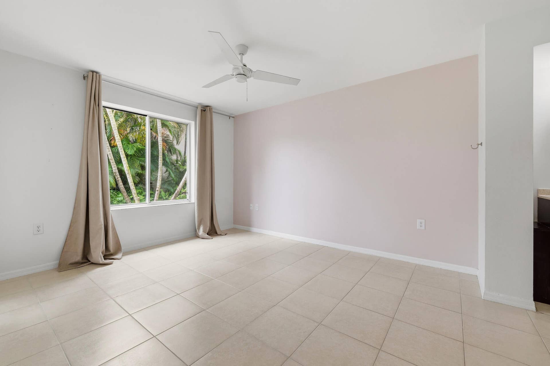 20101 Glenmoor Drive, West Palm Beach, West Palm Beach, FL 33409 Primary bedroom featuring neutral tile flooring and a large window overlooking lush tropical foliage