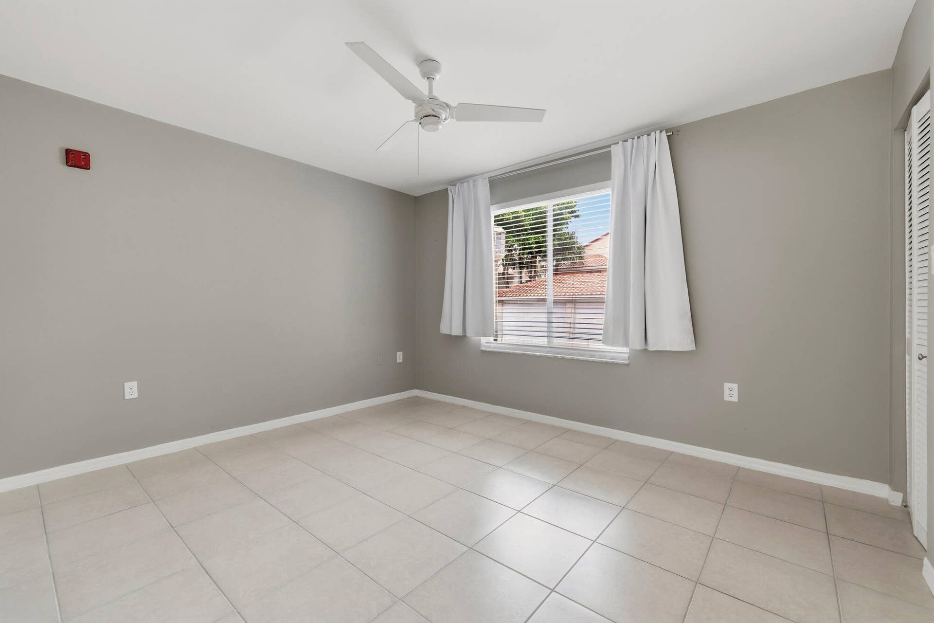 20101 Glenmoor Drive, West Palm Beach, West Palm Beach, FL 33409 Bedroom two featuring neutral gray walls, beige tile flooring, and a white ceiling fan