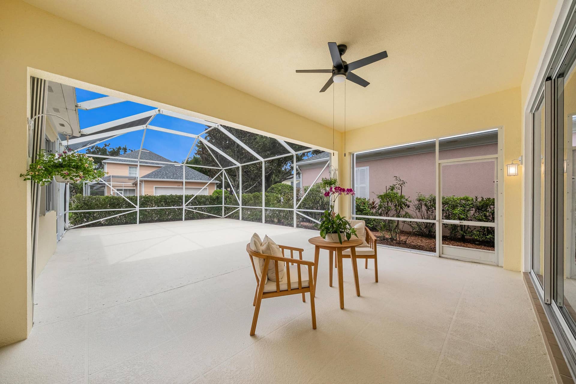 254 Marlberry Circle, Jupiter, FL 33458 Covered seating area of the screened patio, with ceiling fan and open-air space behind