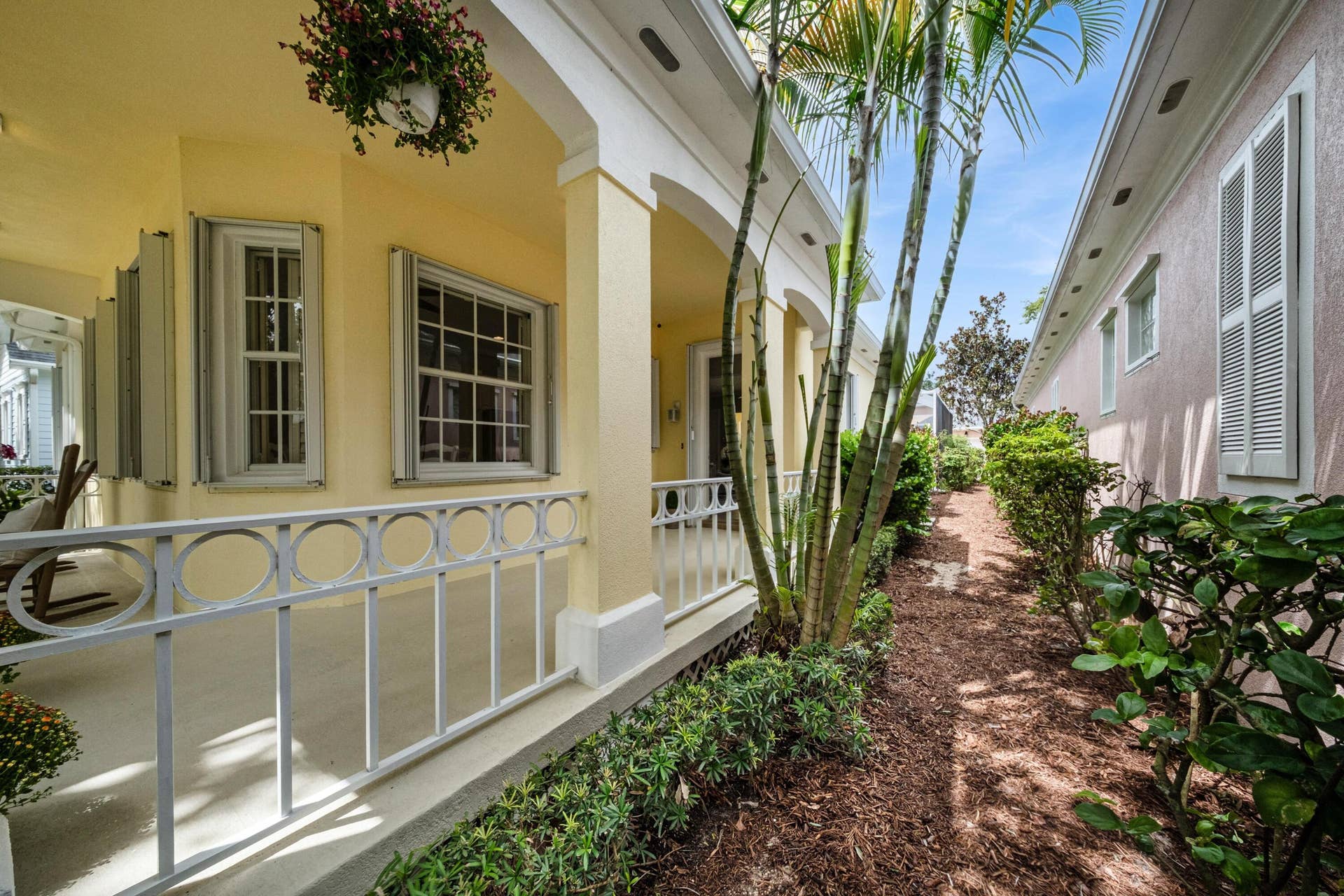 254 Marlberry Circle, Jupiter, FL 33458 Covered front porch detail with circle-motif railings and a landscaped side garden path