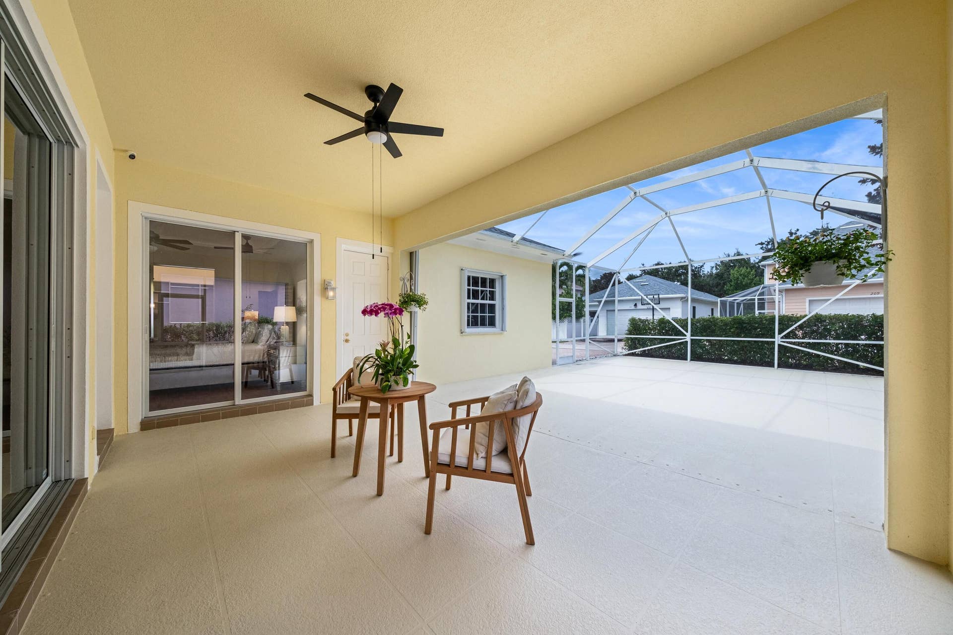 254 Marlberry Circle, Jupiter, FL 33458 Covered end of the screened patio, with sliders to the living room and primary suite