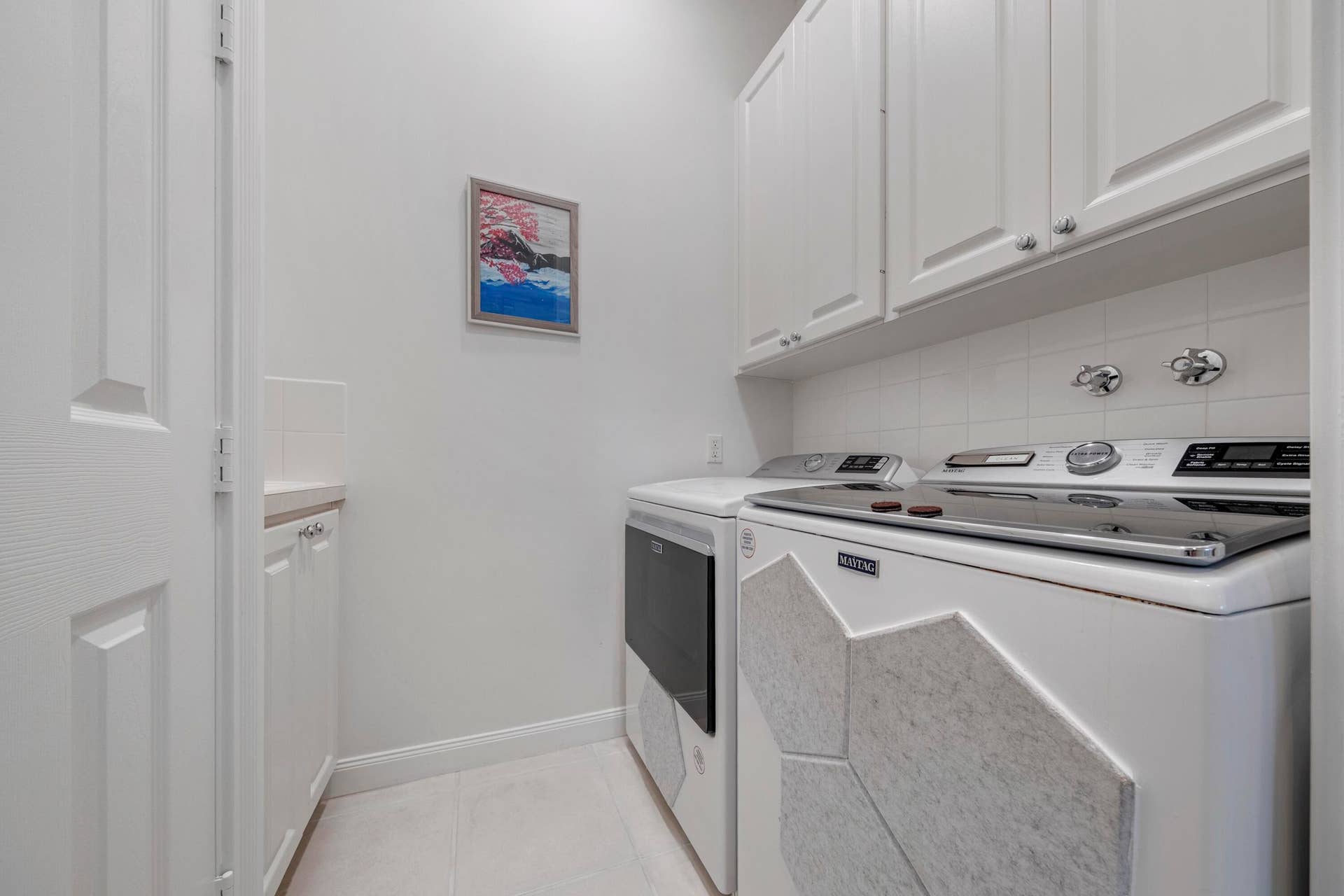 254 Marlberry Circle, Jupiter, FL 33458 Laundry room with newer Maytag washer, dryer, upper cabinetry and utility sink to the left
