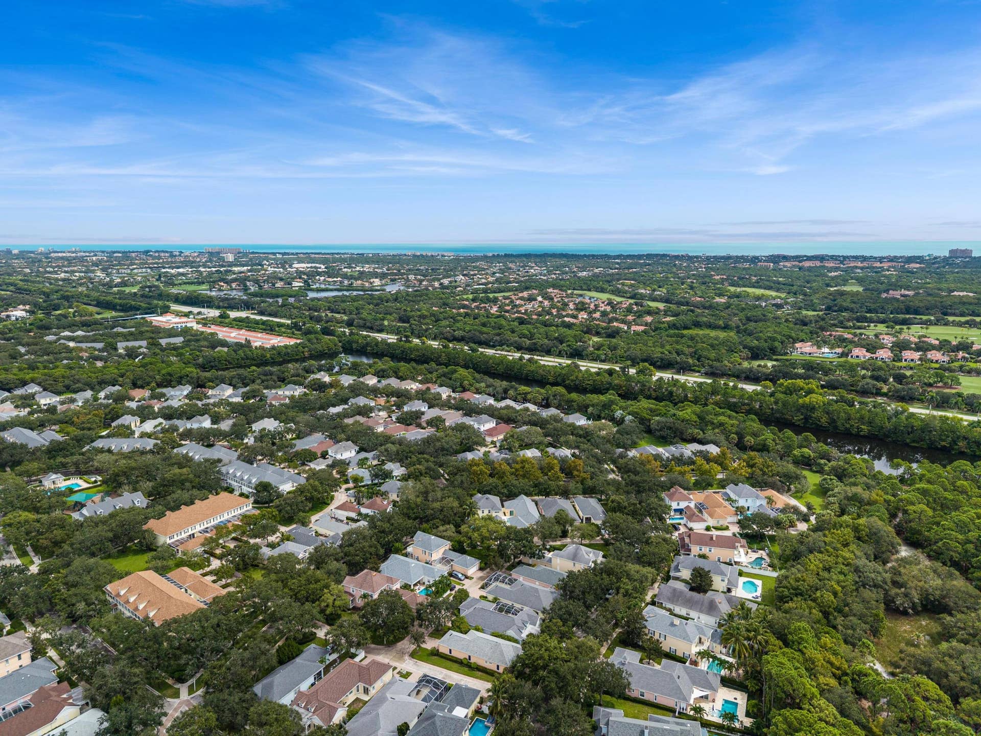 254 Marlberry Circle, Jupiter, FL 33458 Elevated view across the neighborhood's tree canopy toward the Atlantic Ocean