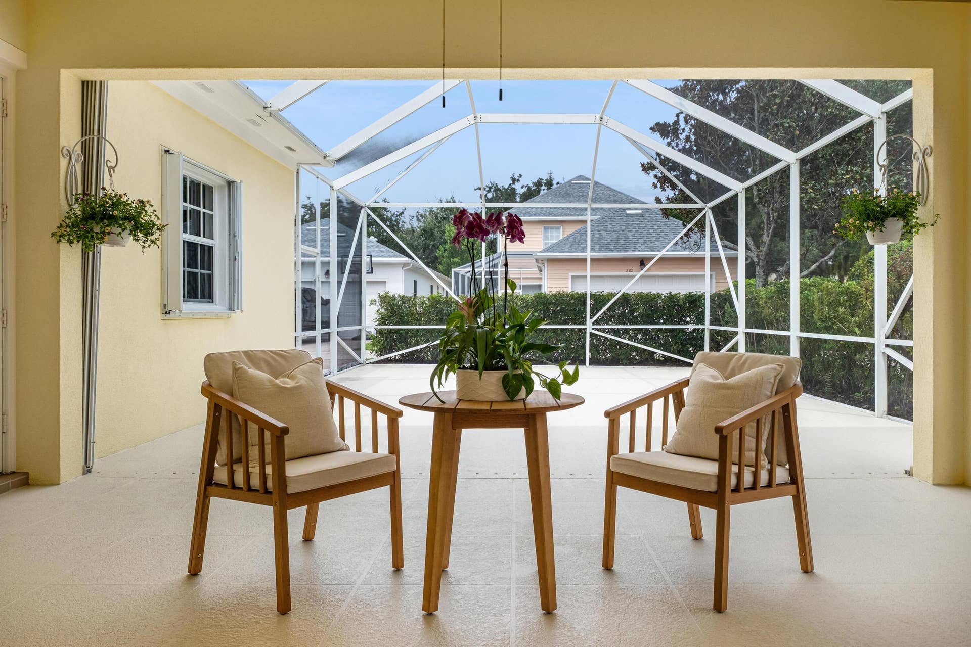 254 Marlberry Circle, Jupiter, FL 33458 Covered seating area with a framed view across the screened patio