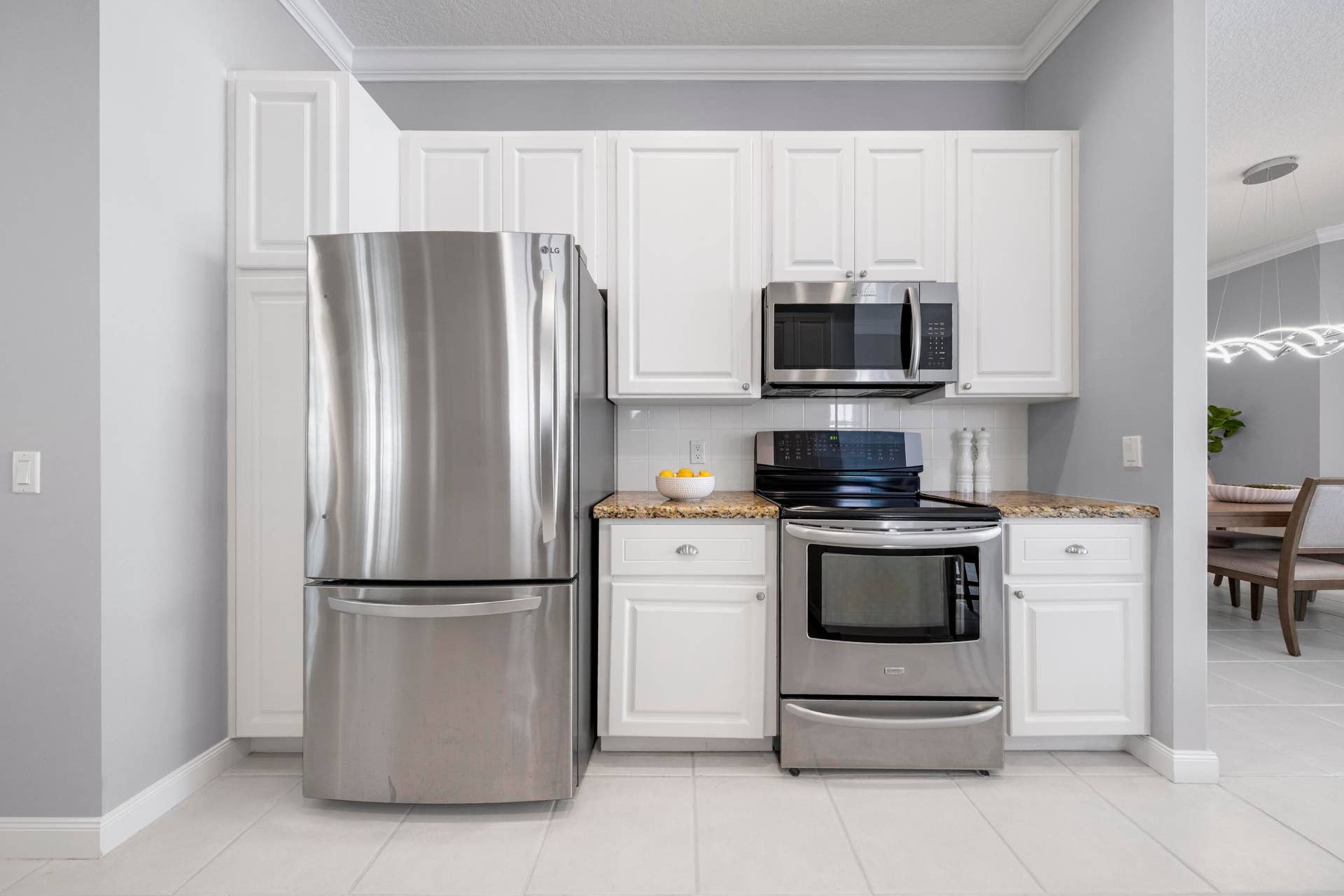 254 Marlberry Circle, Jupiter, FL 33458 Newer stainless refrigerator, range and microwave framed by white cabinetry and granite