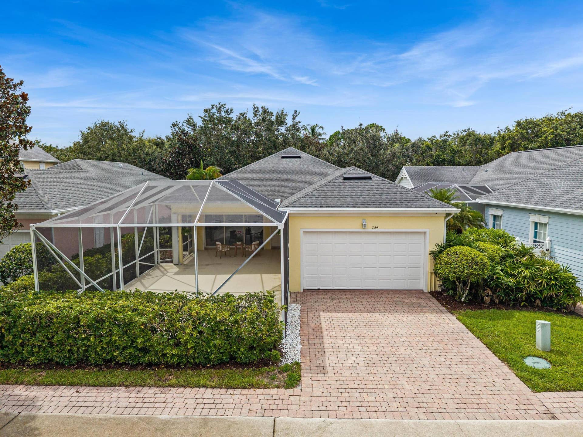 254 Marlberry Circle, Jupiter, FL 33458 Rear elevation with two-car garage, paver driveway and screened patio enclosure