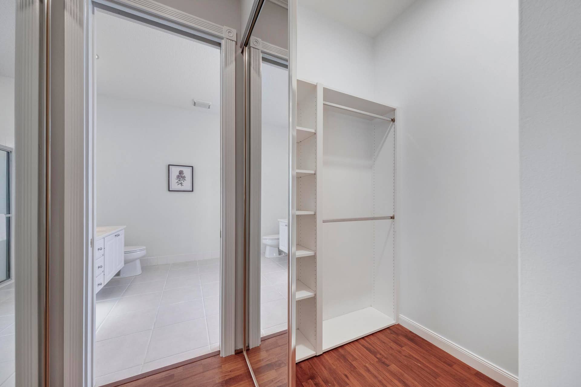254 Marlberry Circle, Jupiter, FL 33458 Primary closet with built-in shelving, opening to the primary bathroom