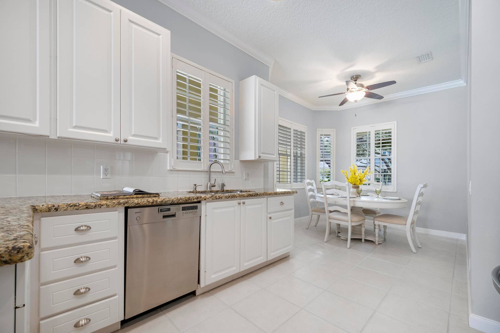 254 Marlberry Circle, Jupiter, FL 33458 Double sink beneath plantation shutters, beside a window-lined breakfast nook with plenty of natural light