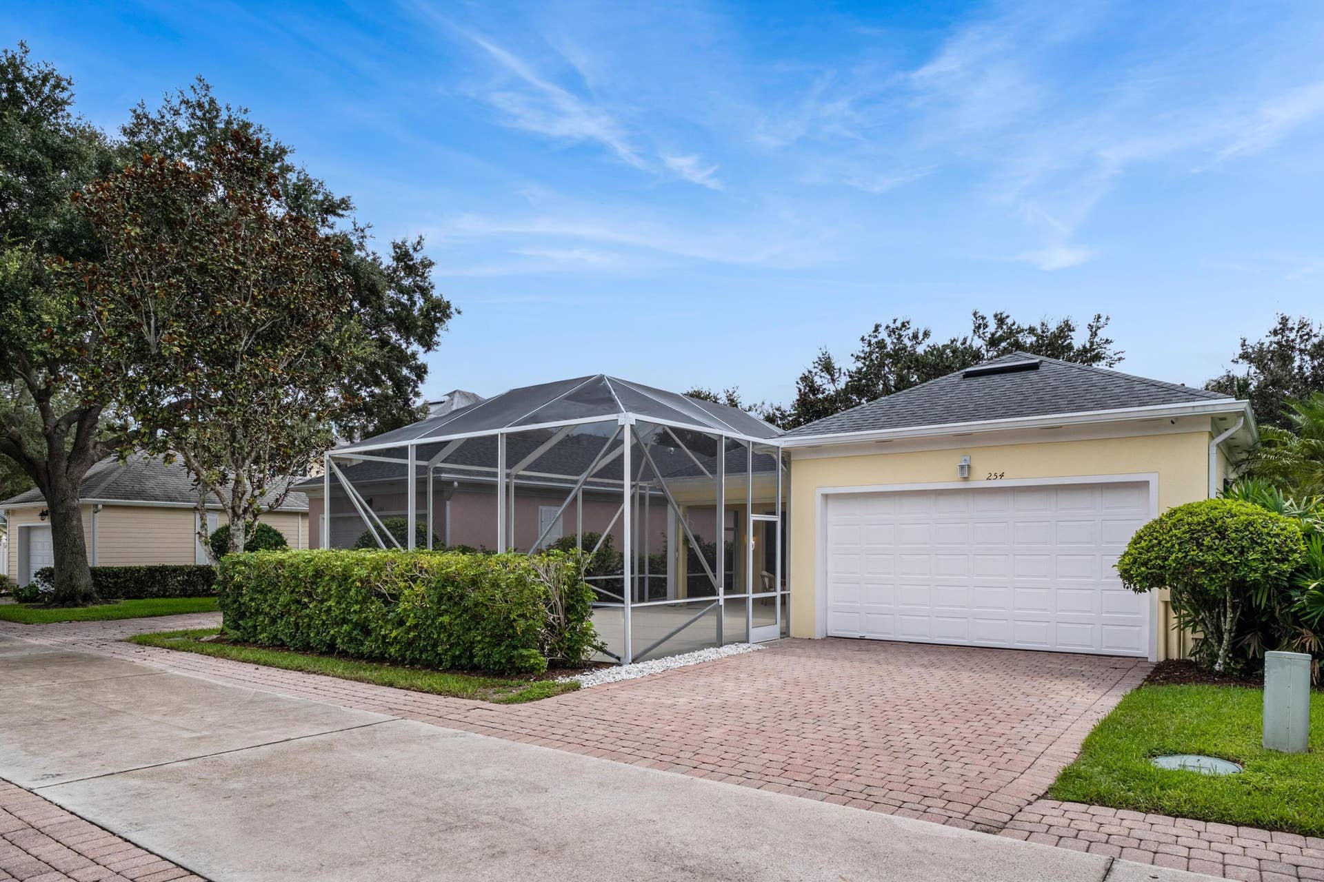 254 Marlberry Circle, Jupiter, FL 33458 Rear-loaded two-car garage on a paver lane, beside the screened patio