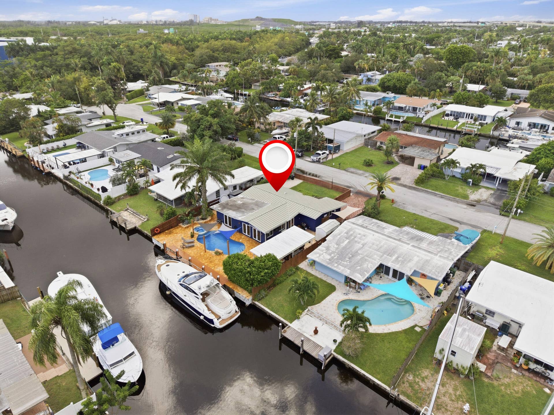 2496 BIMINI Lane, Fort Lauderdale, FL 33312 Waterfront property featuring a private boat dock, in-ground swimming pool, and mature palm trees