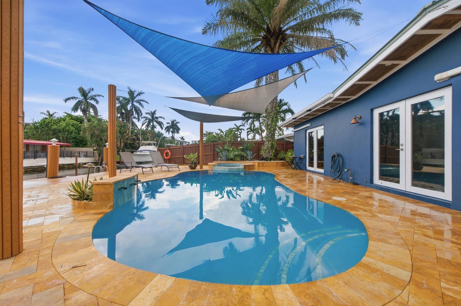 2496 BIMINI Lane, Fort Lauderdale, FL 33312 Freeform pool with a spa, surrounded by natural stone tile paving