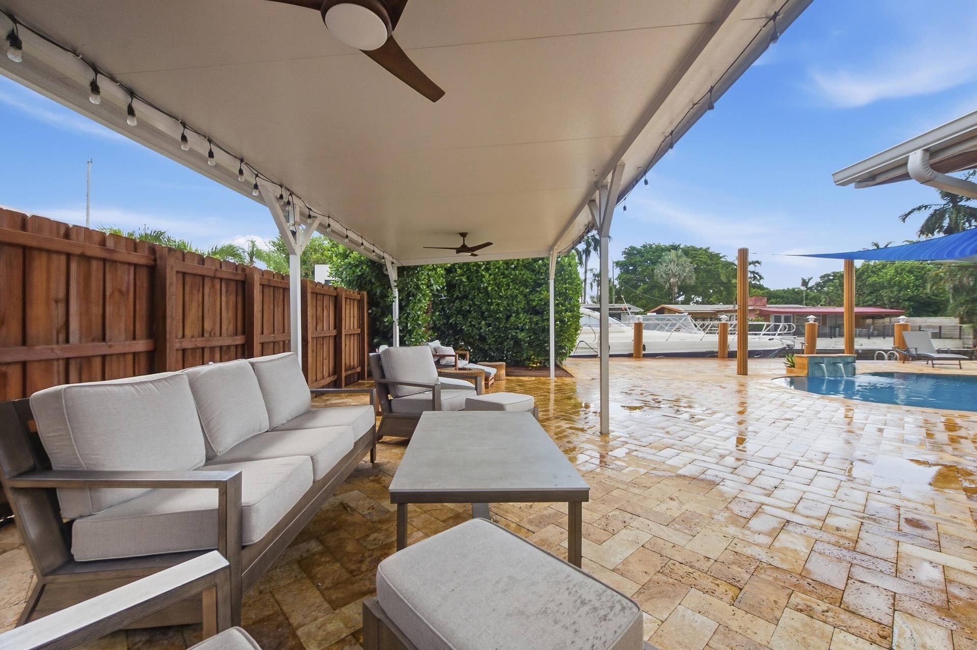2496 BIMINI Lane, Fort Lauderdale, FL 33312 Covered patio with integrated ceiling fans, string lighting, paver patio, and a dedicated pool area