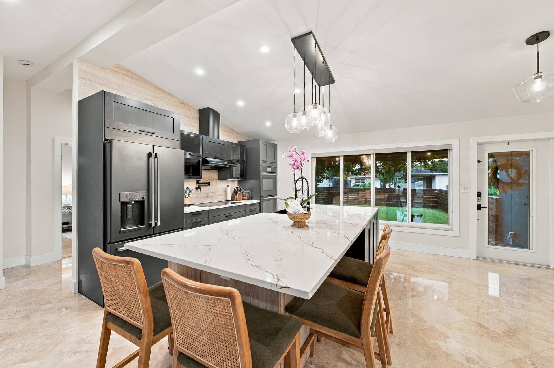 2496 BIMINI Lane, Fort Lauderdale, FL 33312 Expansive kitchen island with a white veined countertop, dark cabinetry, stainless steel appliances, and recessed lighting