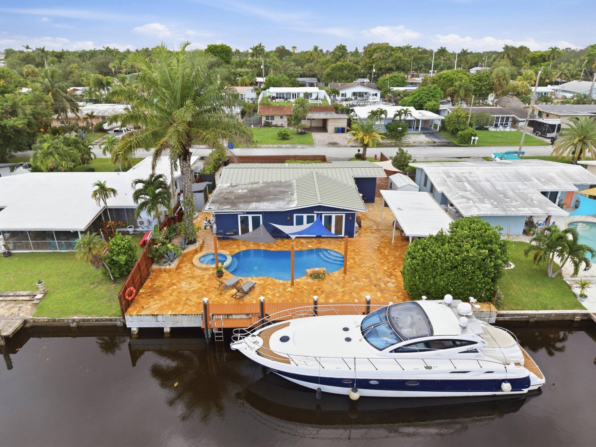 2496 BIMINI Lane, Fort Lauderdale, FL 33312 Waterfront property with a private dock, blue exterior, swimming pool, and adjacent hot tub