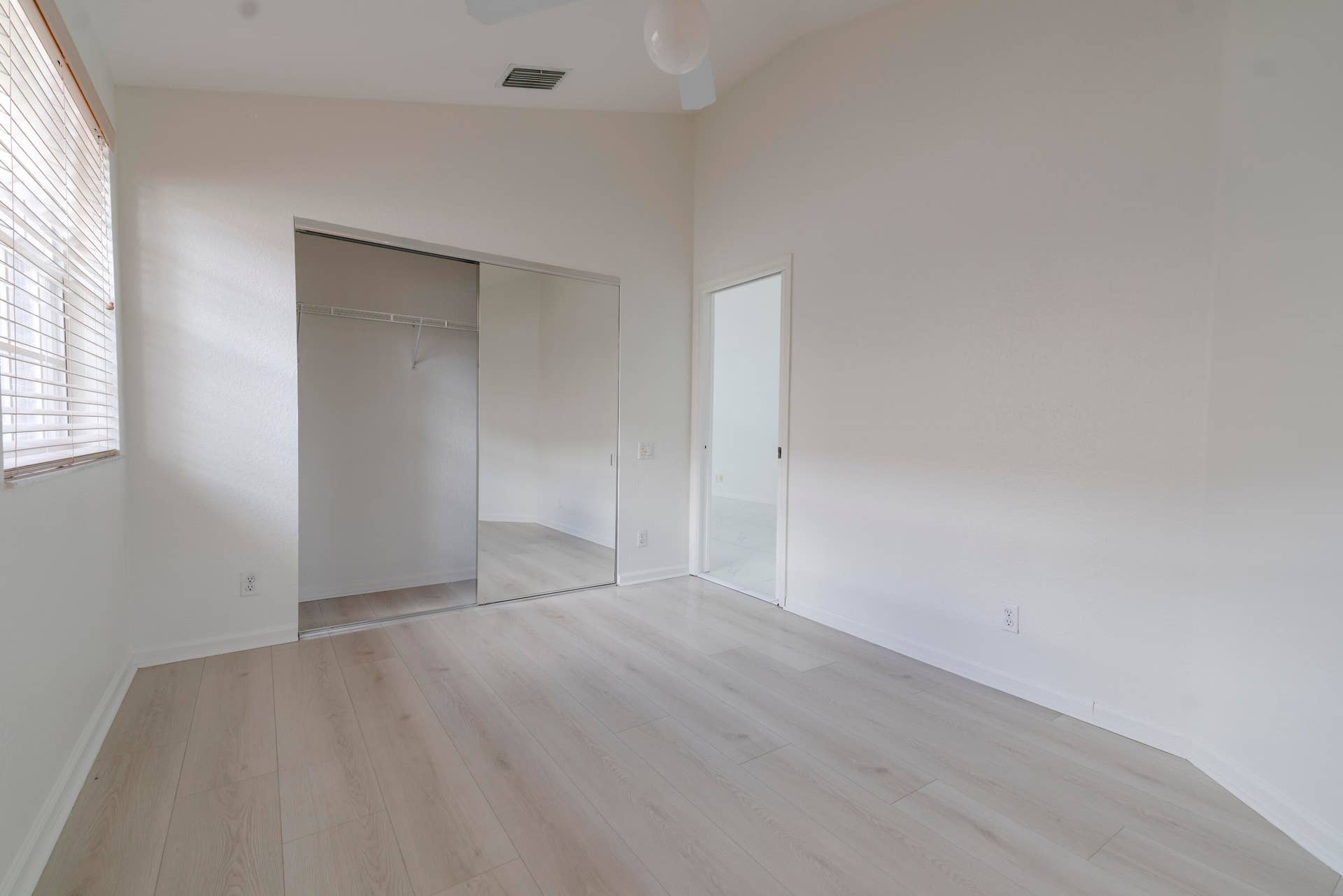6162 BAY ISLES Drive, Boynton Beach, FL 33437 Vaulted ceiling, wood-finish flooring, mirrored closet doors, and ceiling fan