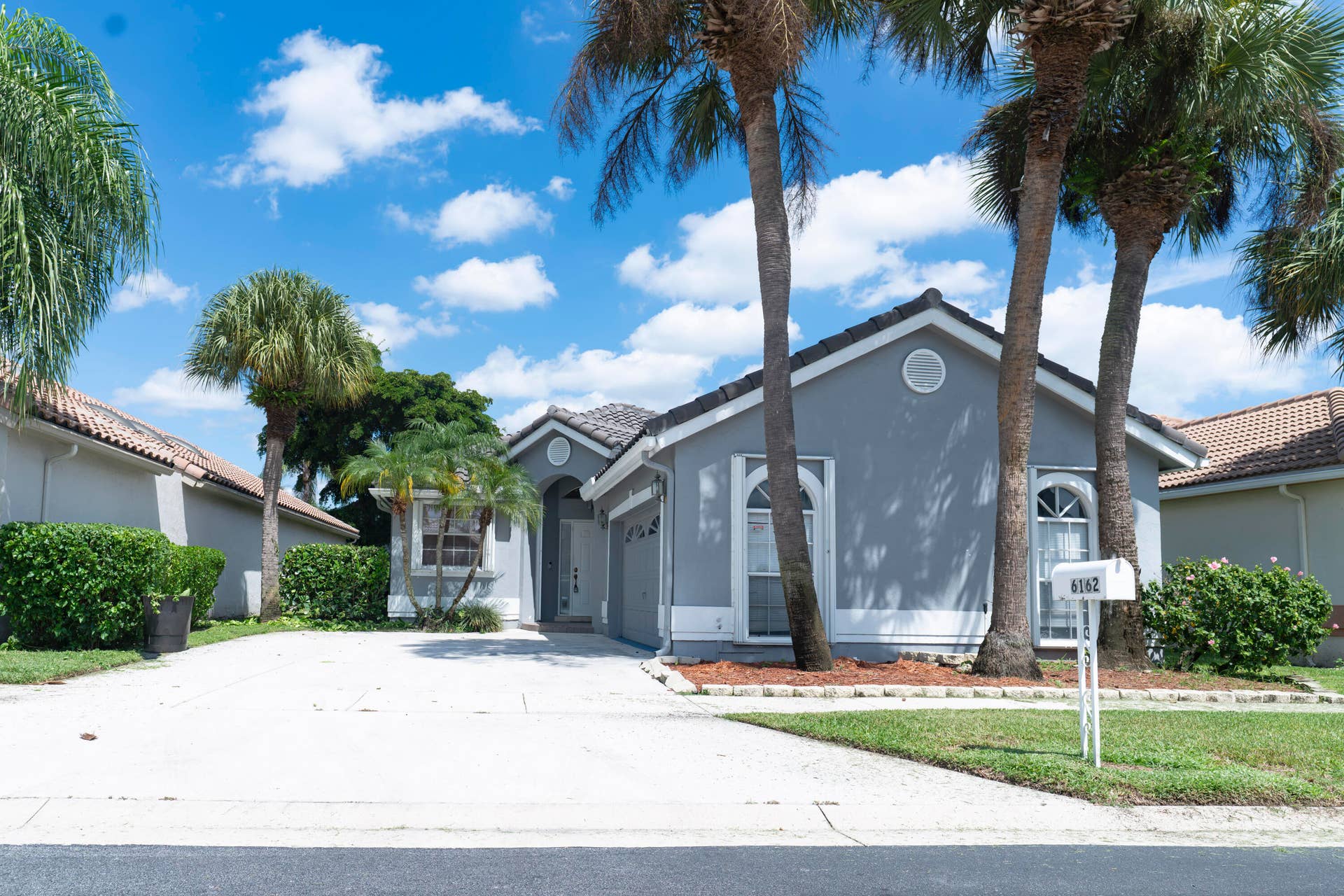 6162 BAY ISLES Drive, Boynton Beach, FL 33437 Stucco exterior with a tiled roof, arched entry, and decorative windows