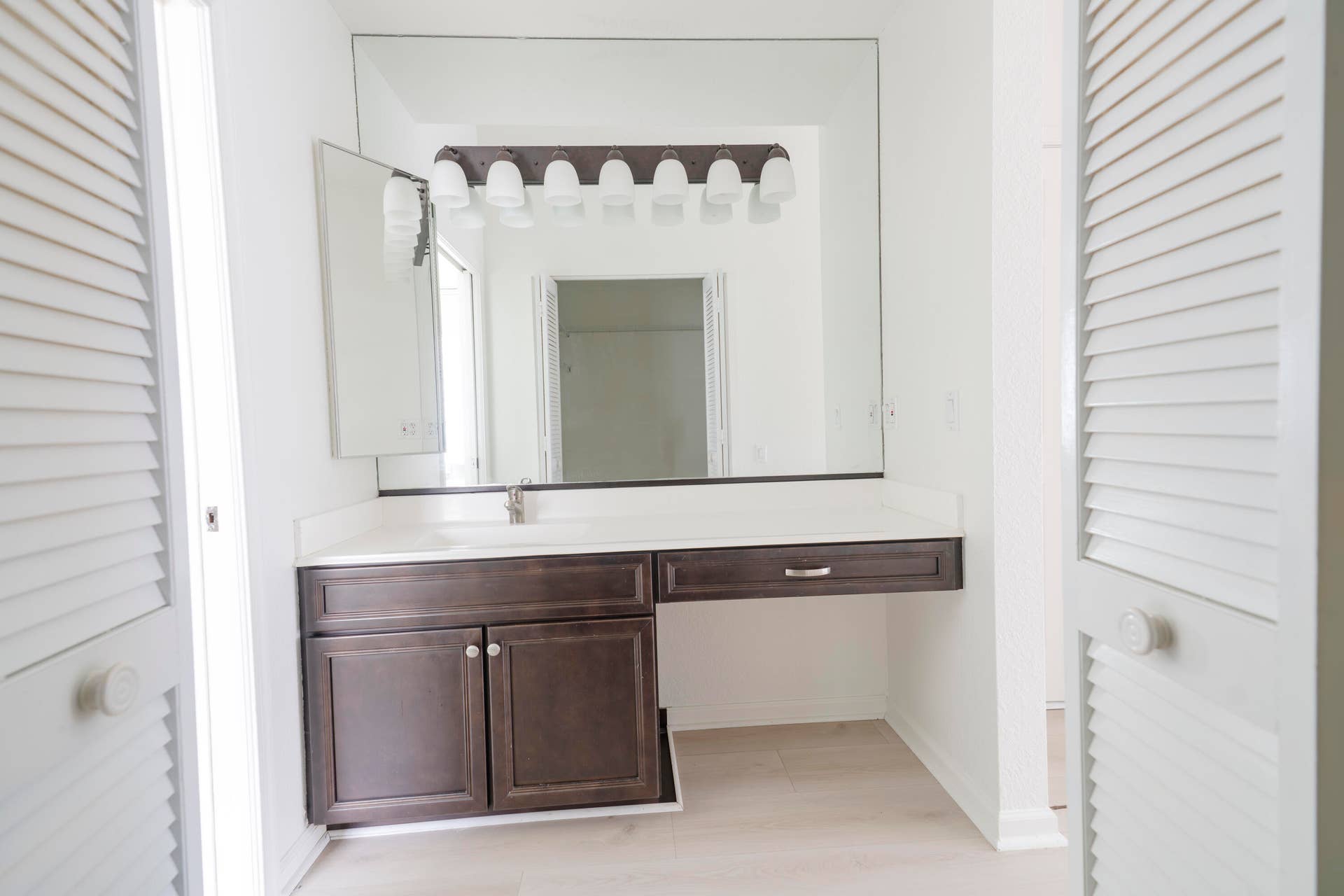 6162 BAY ISLES Drive, Boynton Beach, FL 33437 Vanity with an integrated sink, polished chrome faucet, built-in storage, and a large wall-mounted mirror