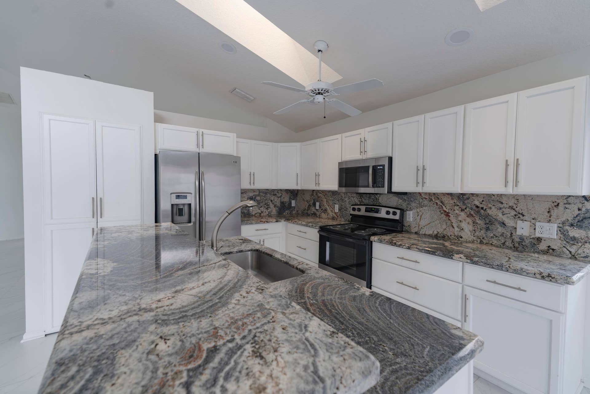 6162 BAY ISLES Drive, Boynton Beach, FL 33437 Kitchen featuring white cabinetry, stainless steel appliances, a ceiling fan, and granite countertops