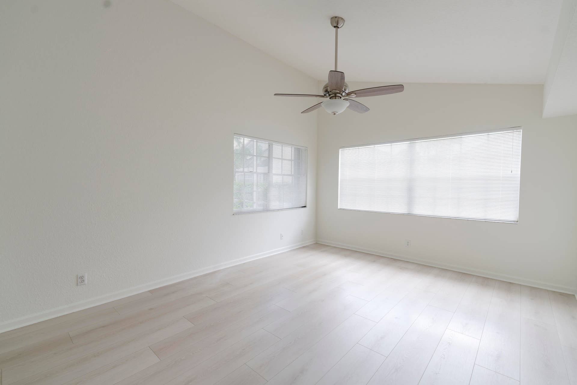 6162 BAY ISLES Drive, Boynton Beach, FL 33437 Vaulted ceiling with a ceiling fan, light wood-finish flooring, and multiple windows with blinds
