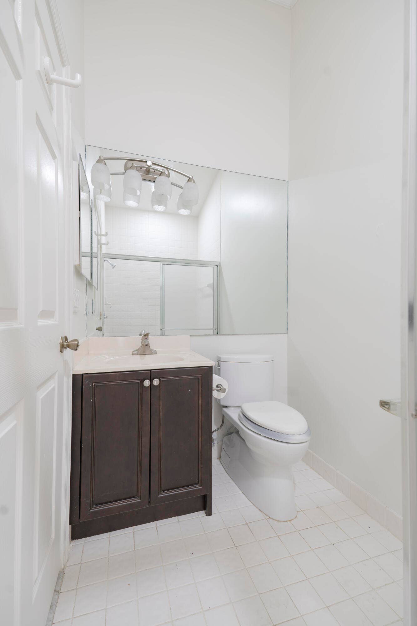 6162 BAY ISLES Drive, Boynton Beach, FL 33437 Bathroom featuring a dark wood-finish vanity with a light-toned countertop, a large wall-mounted mirror, and a white toilet