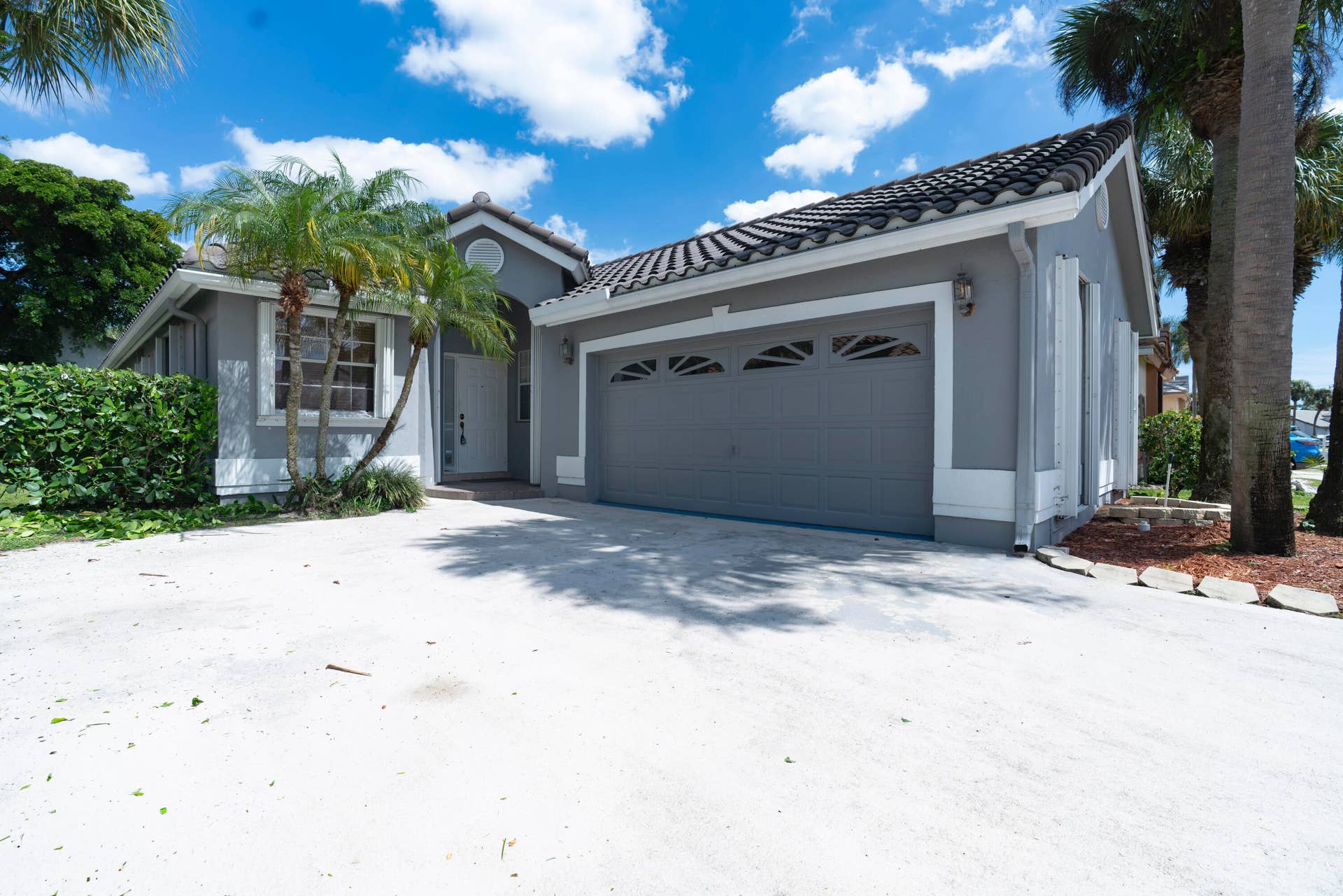 6162 BAY ISLES Drive, Boynton Beach, FL 33437 Stucco exterior with a tiled roof, attached two-car garage, and a concrete driveway
