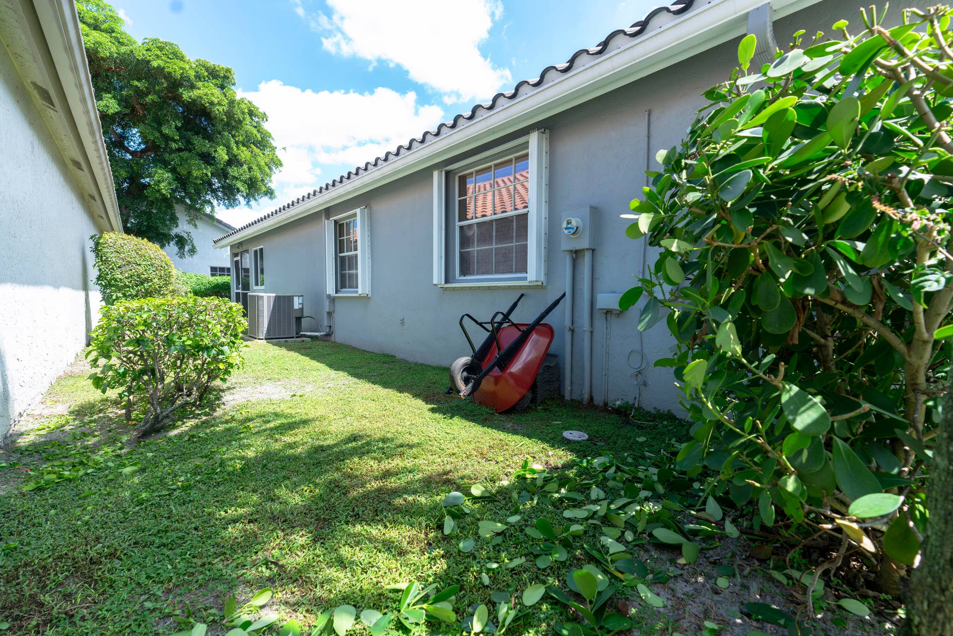 6162 BAY ISLES Drive, Boynton Beach, FL 33437 Exterior wall with multiple windows, stucco finish, and a tile roof