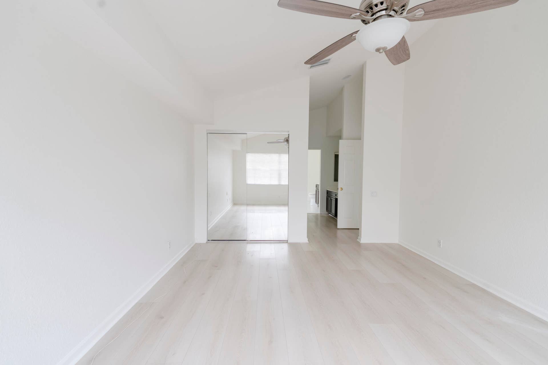 6162 BAY ISLES Drive, Boynton Beach, FL 33437 Vaulted ceilings with a ceiling fan, light wood-finish flooring, and mirrored closet doors