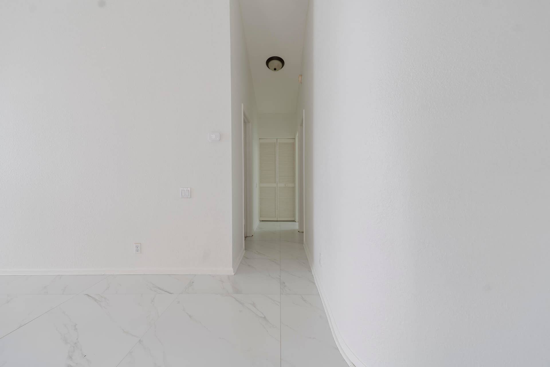 6162 BAY ISLES Drive, Boynton Beach, FL 33437 White walls with a recessed light fixture and a hallway featuring a louvered door