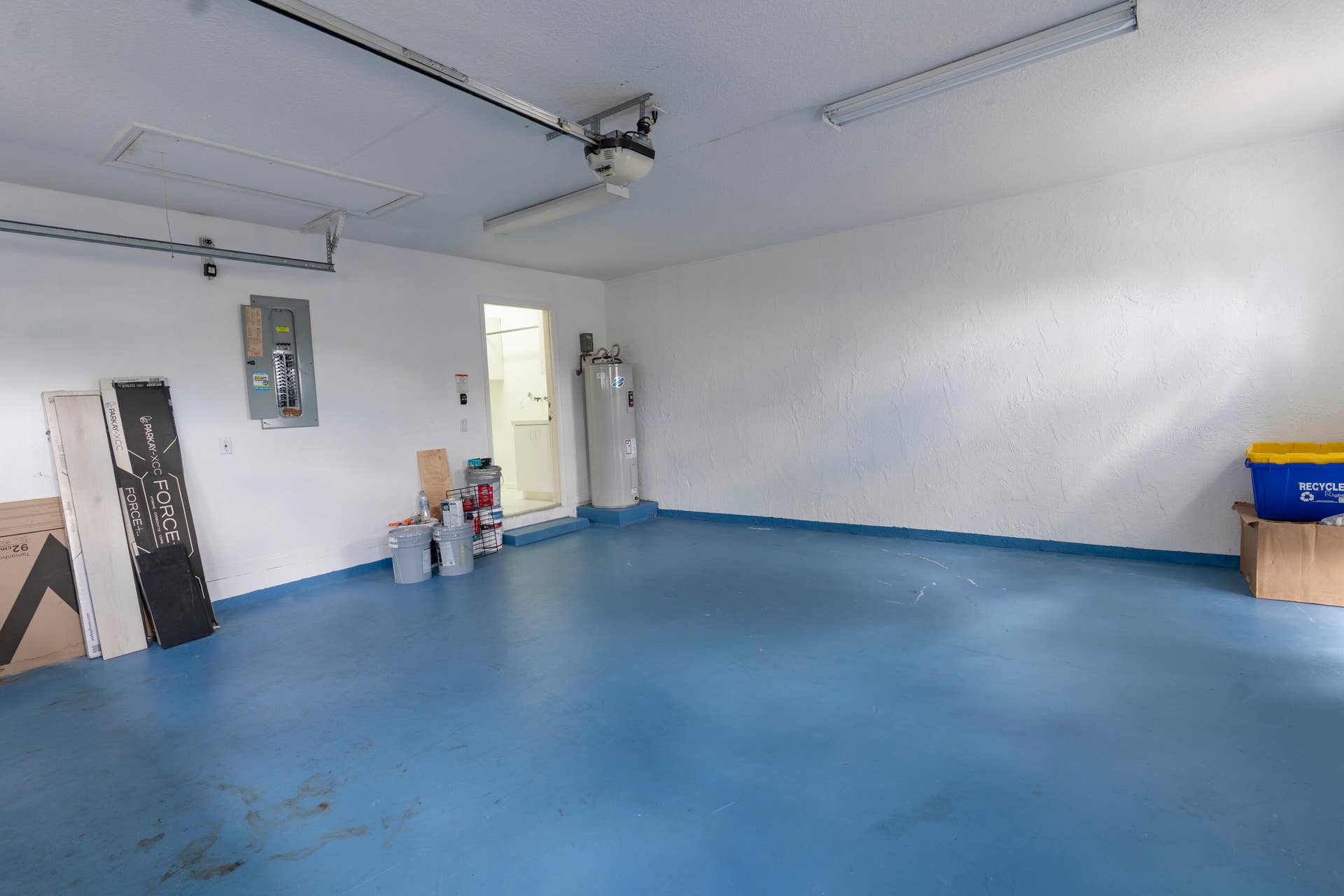 6162 BAY ISLES Drive, Boynton Beach, FL 33437 Garage with a durable blue floor finish, overhead garage door opener, and accessible utility panel