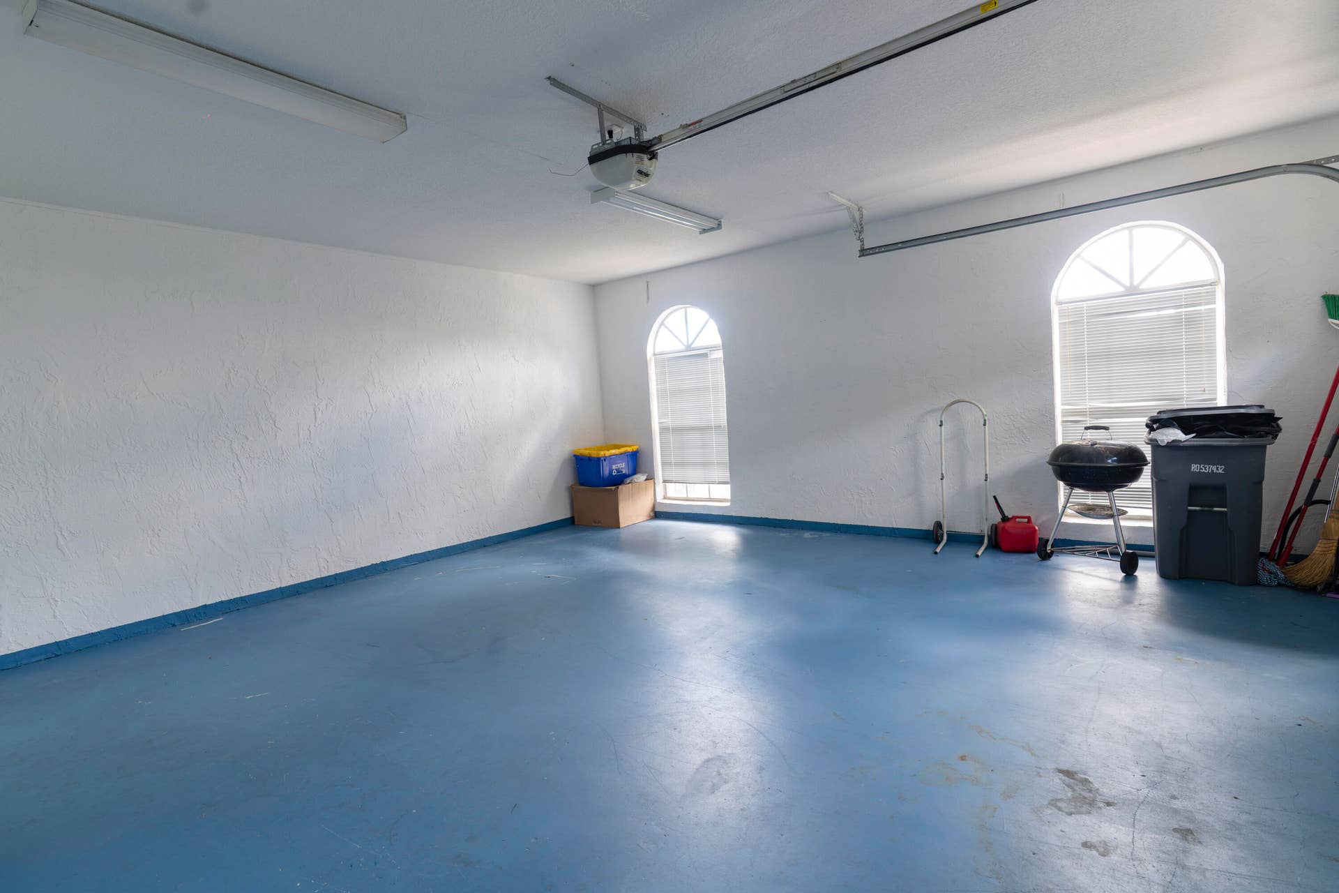 6162 BAY ISLES Drive, Boynton Beach, FL 33437 Spacious garage featuring a blue-painted concrete floor and two arched windows