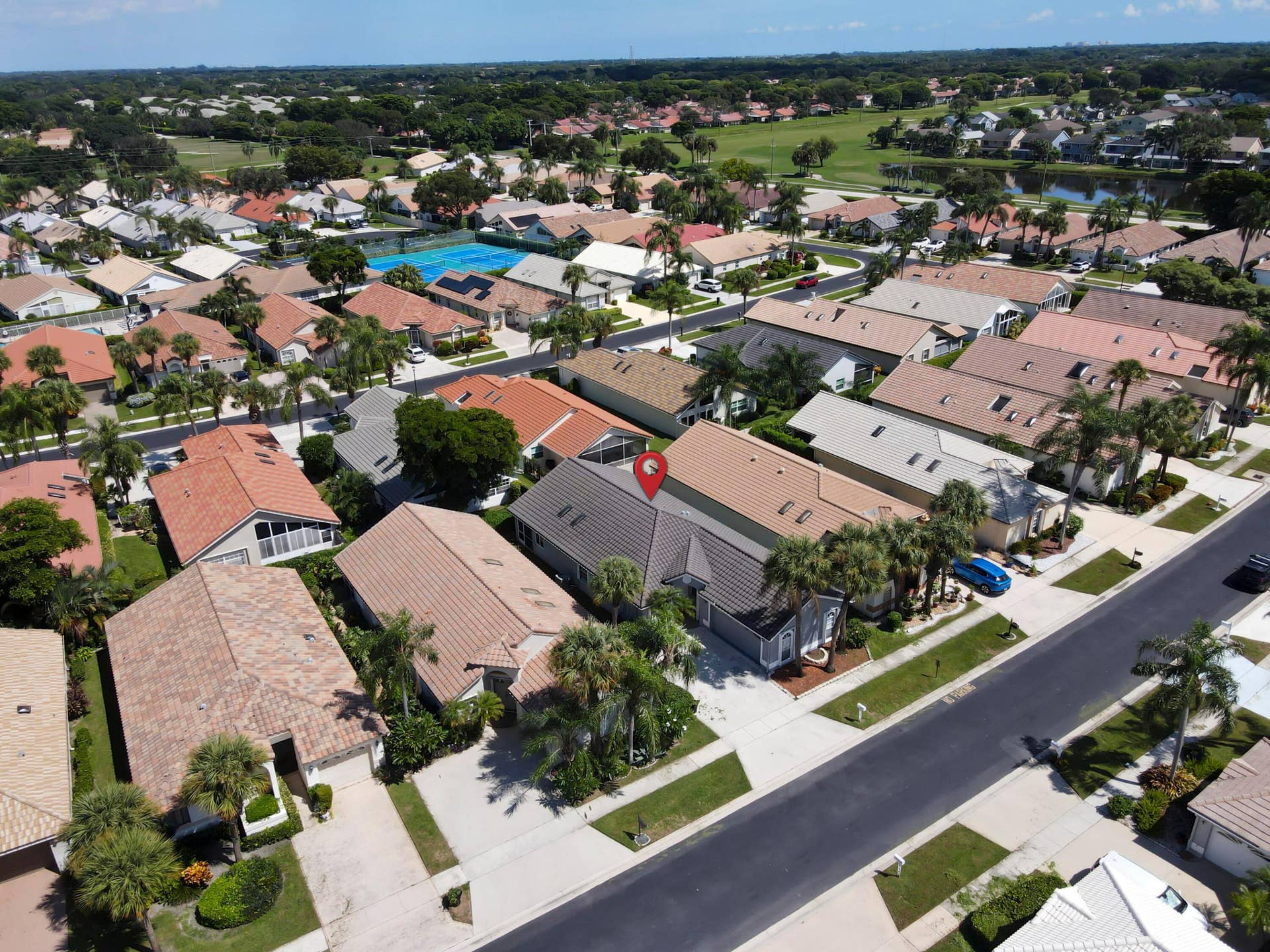 6162 BAY ISLES Drive, Boynton Beach, FL 33437 Gabled roofline residence with mature palm trees, an attached garage, and paved driveway