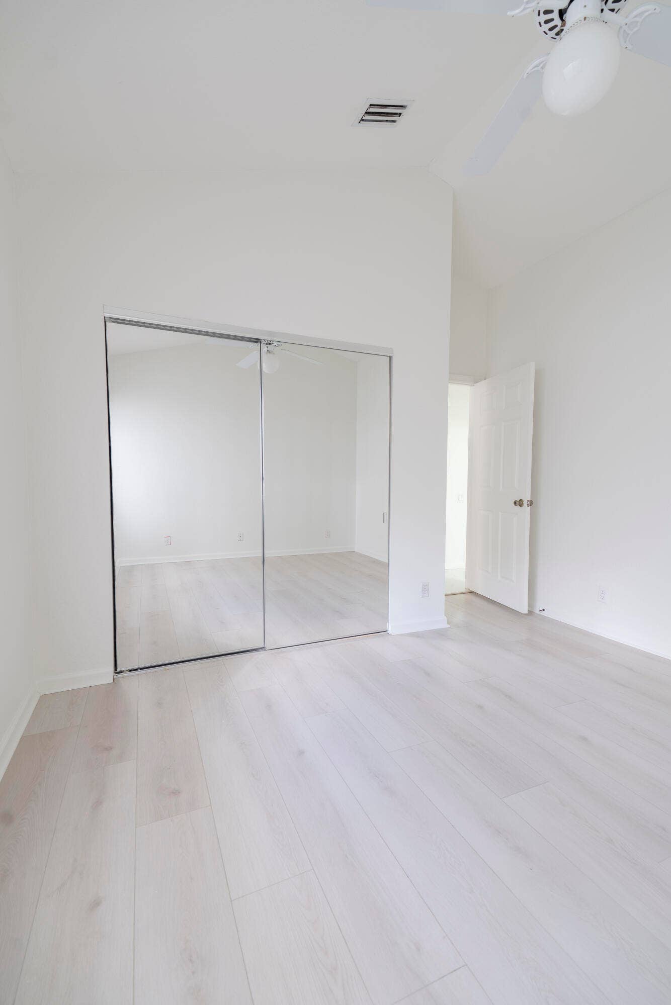 6162 BAY ISLES Drive, Boynton Beach, FL 33437 Vaulted ceiling with a ceiling fan, light wood-finish flooring, and mirrored closet doors