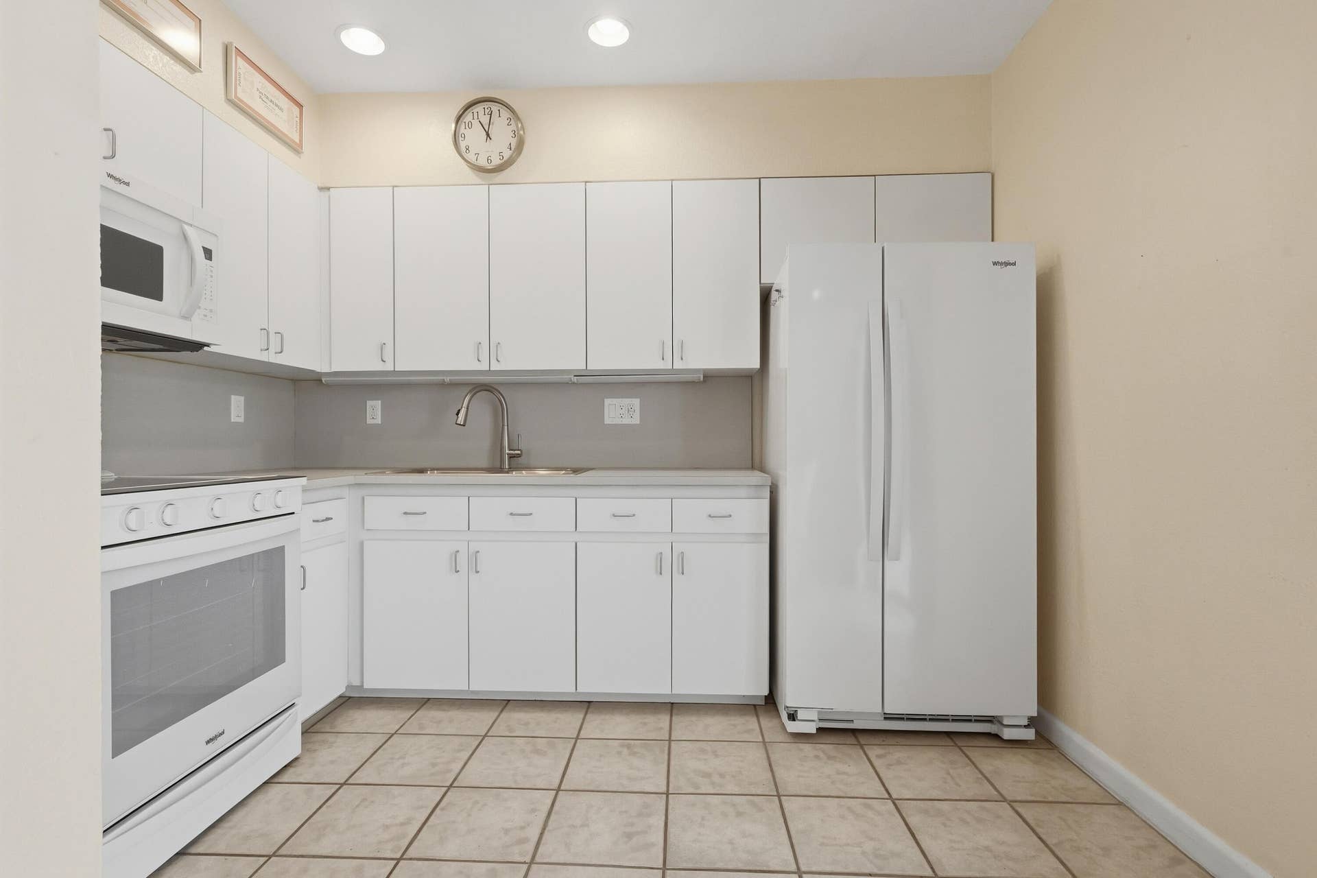 Kitchen featuring white cabinetry, tile flooring, white appliances, and a stainless steel sink with a gooseneck faucet