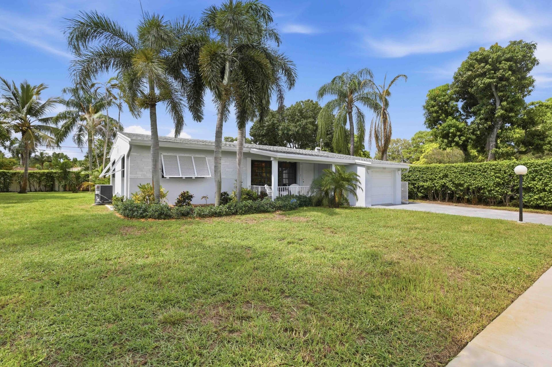 Single-story residence with a white exterior, attached garage, and a stamped concrete driveway