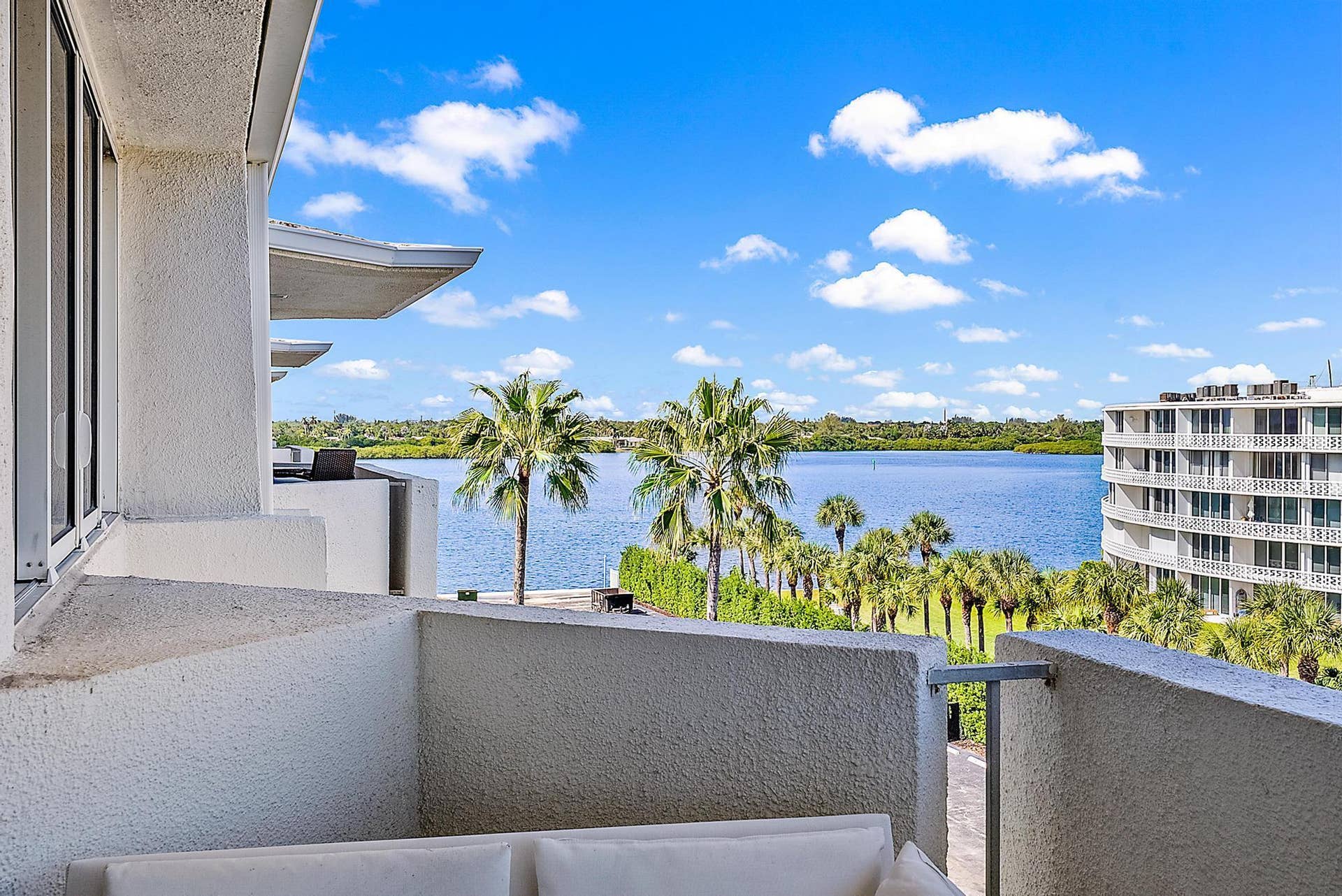 2773 S Ocean Boulevard, #517, Palm Beach, Palm Beach, FL 33480 Balcony with a water backdrop, framed by tropical landscaping and an adjacent building